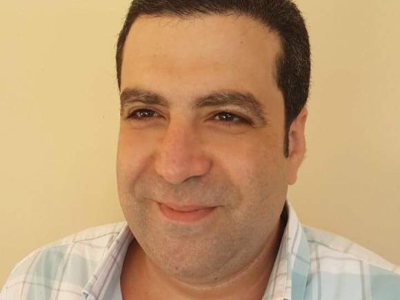 Head shot of a man smiling with black hair