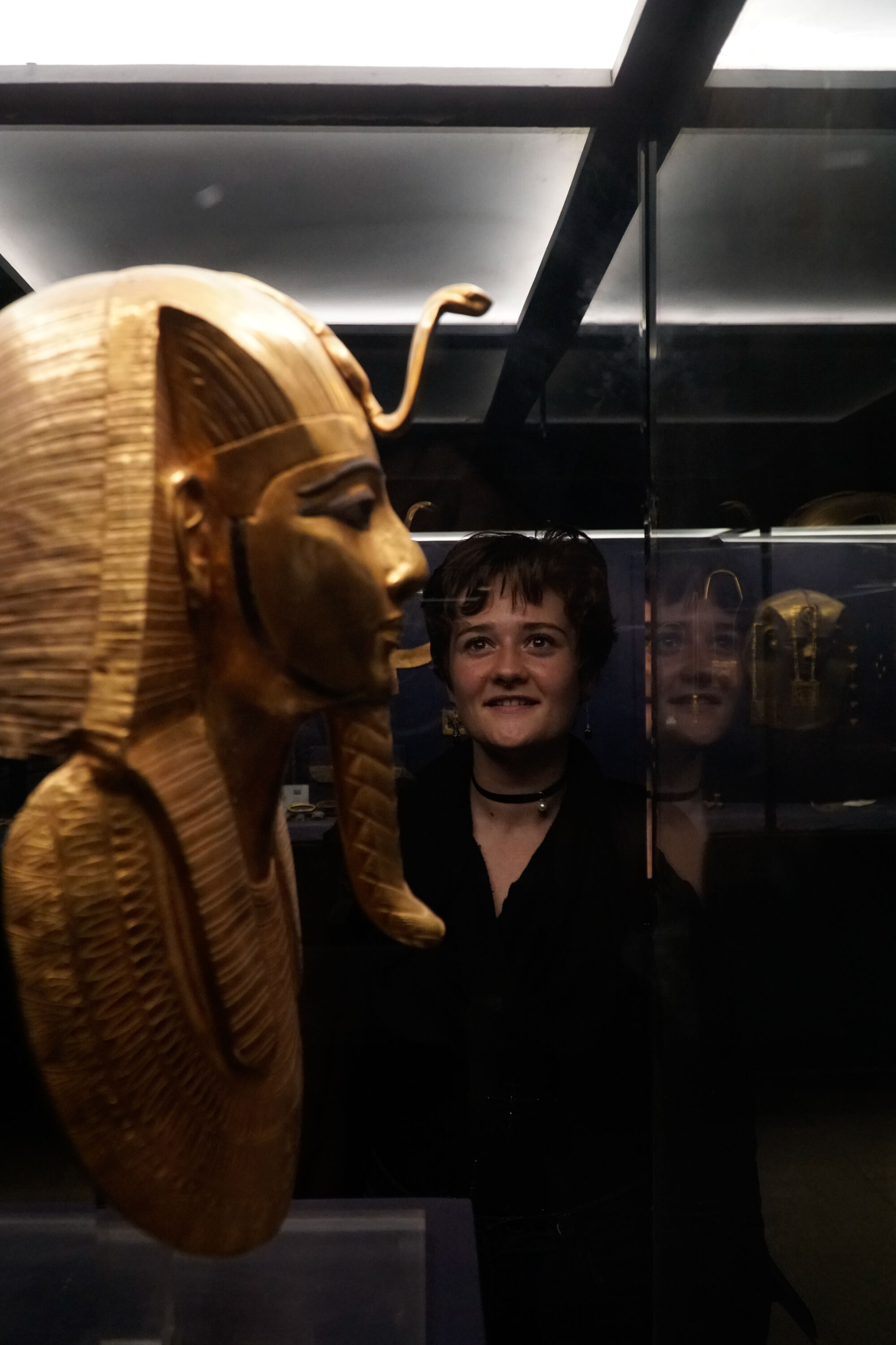 Egyptology graduate program image of student in museum looking at artifacts