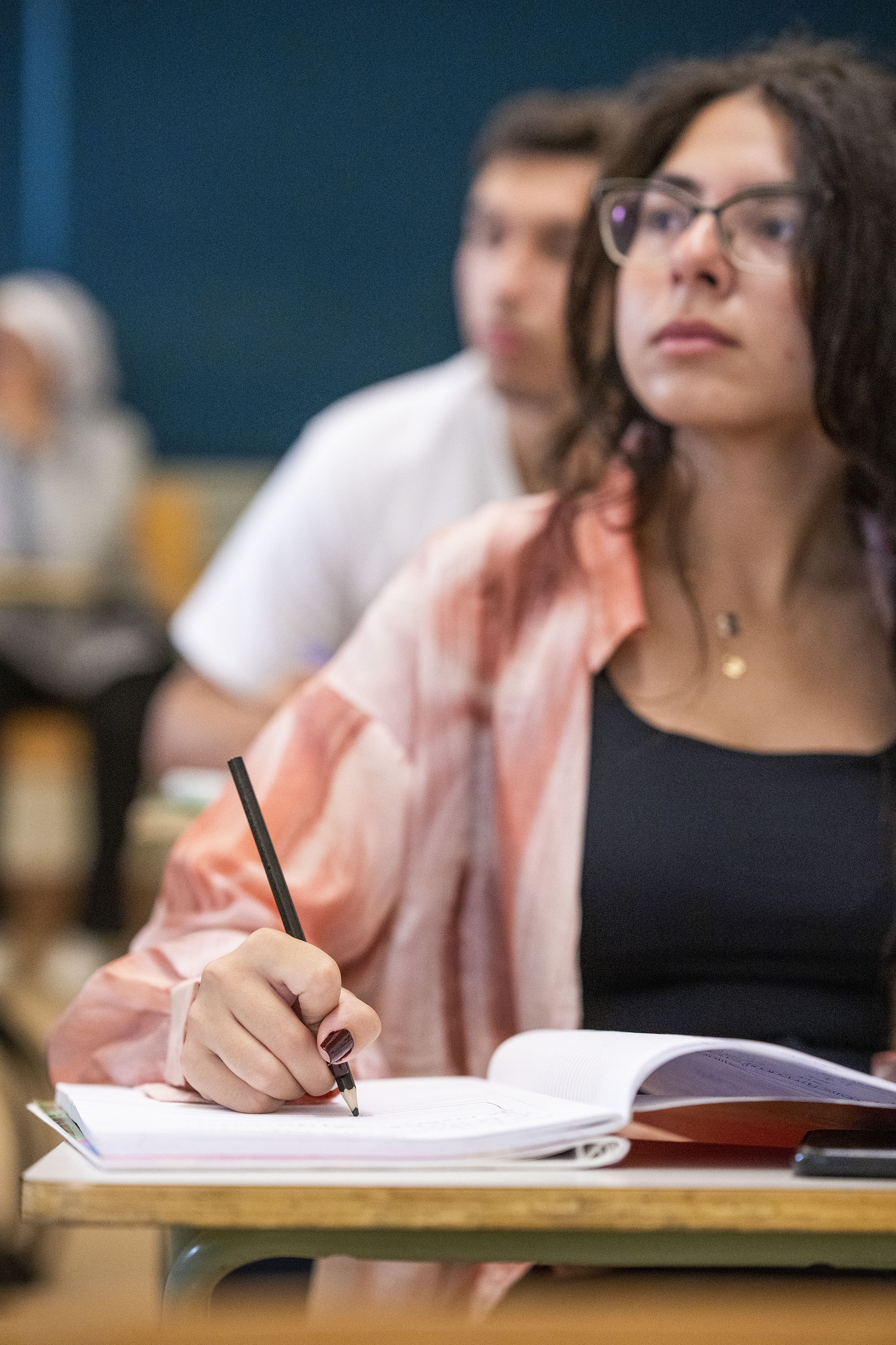 female student in classroom writing notes