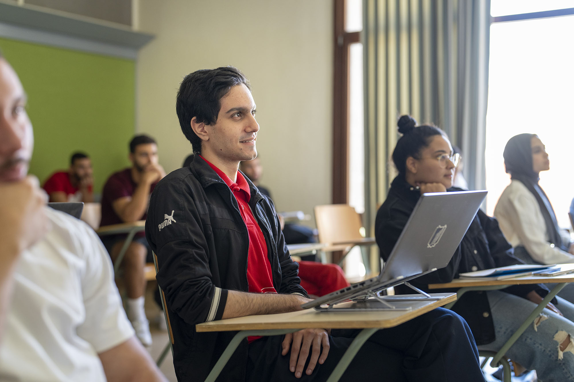 global affairs program image of students in class with focus on a smiling male student