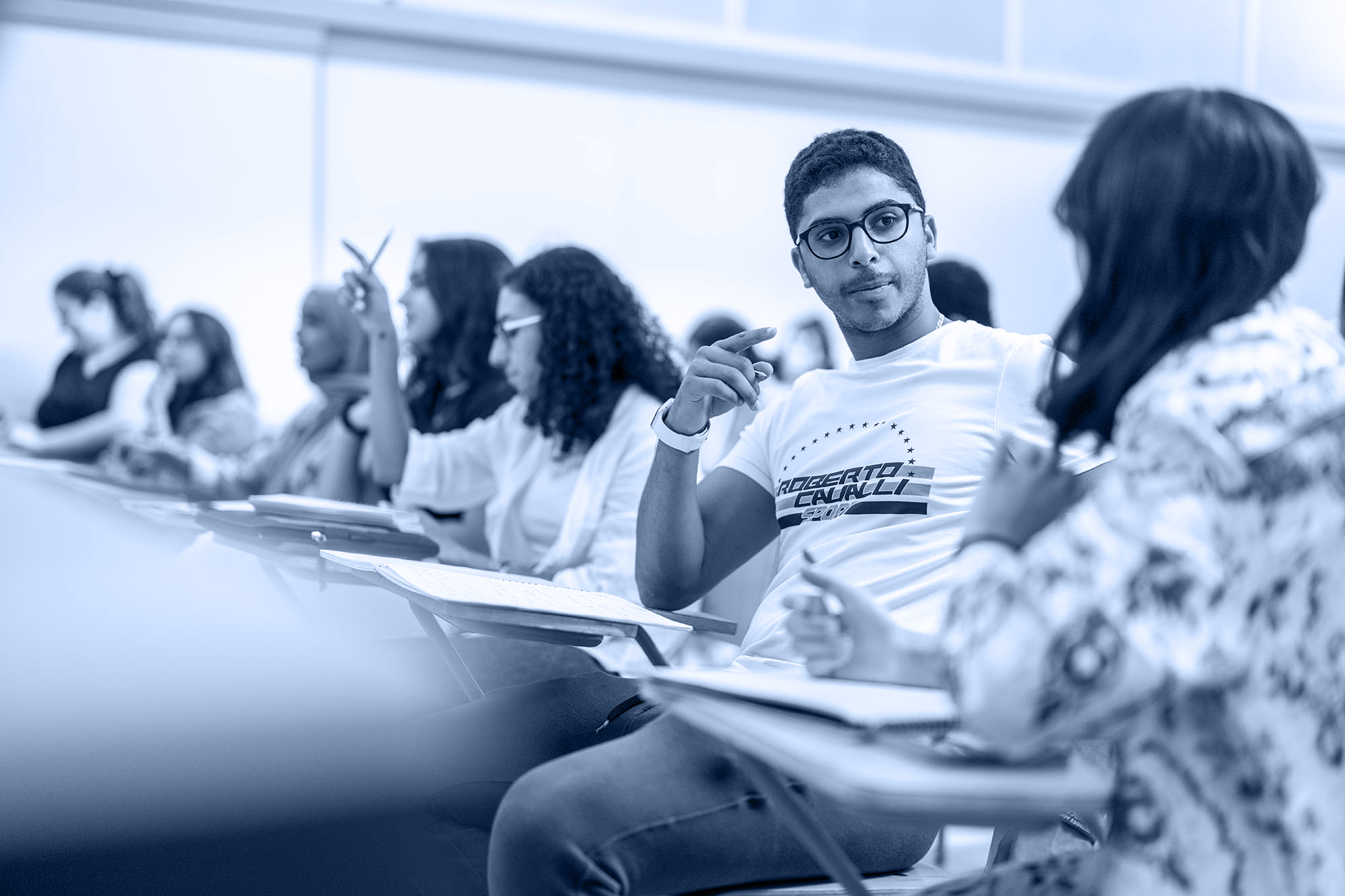 International and comparative law diploma program image of male student discussing a topic with his work partner