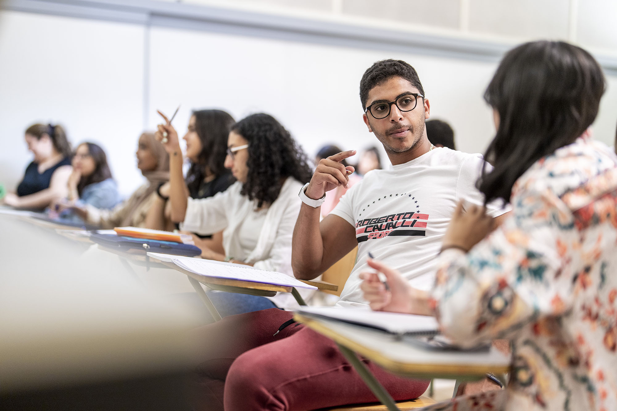 International and comparative law program image of male student discussing a topic with his work partner