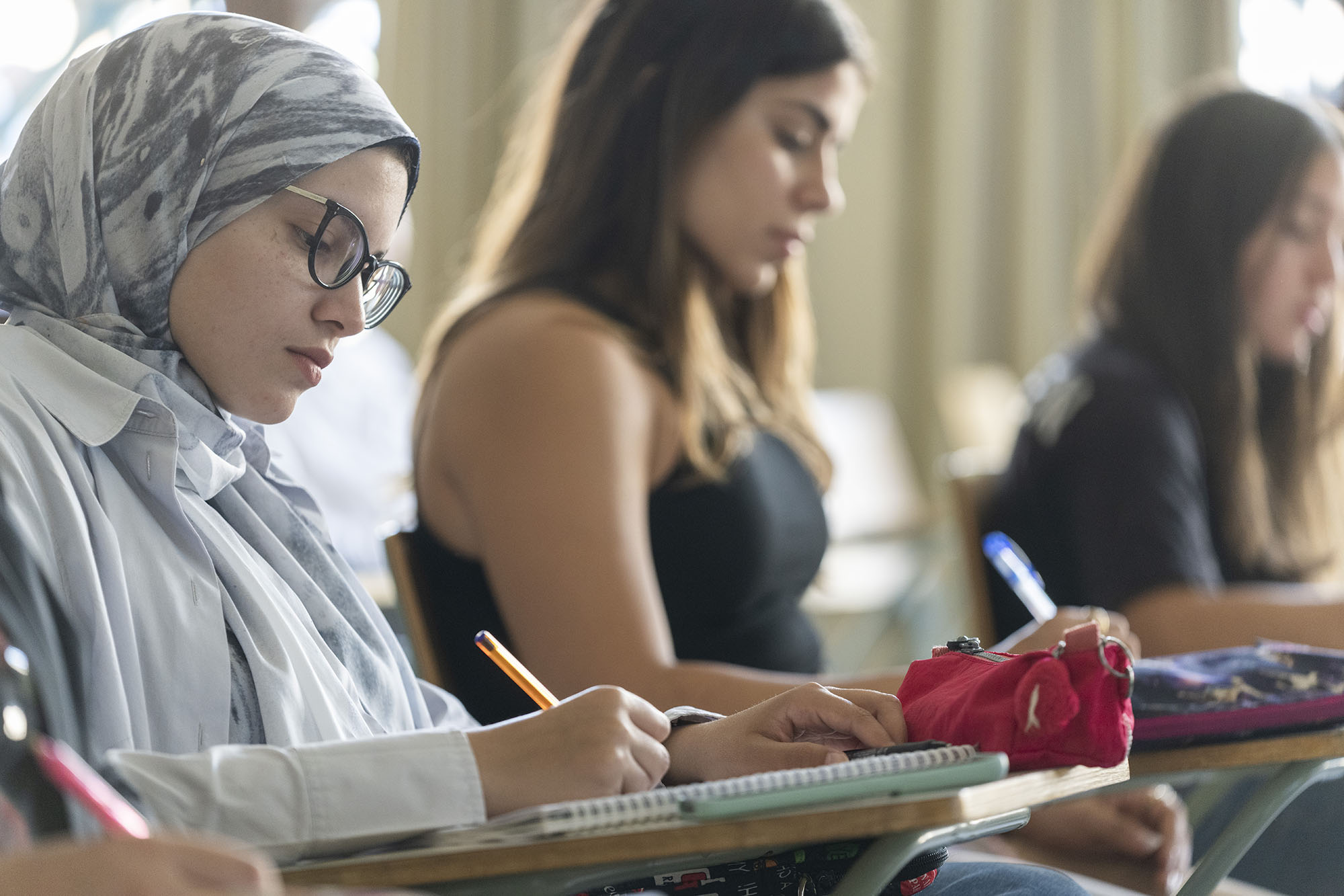 Political Science CEMPS program image of female students taking notes in class