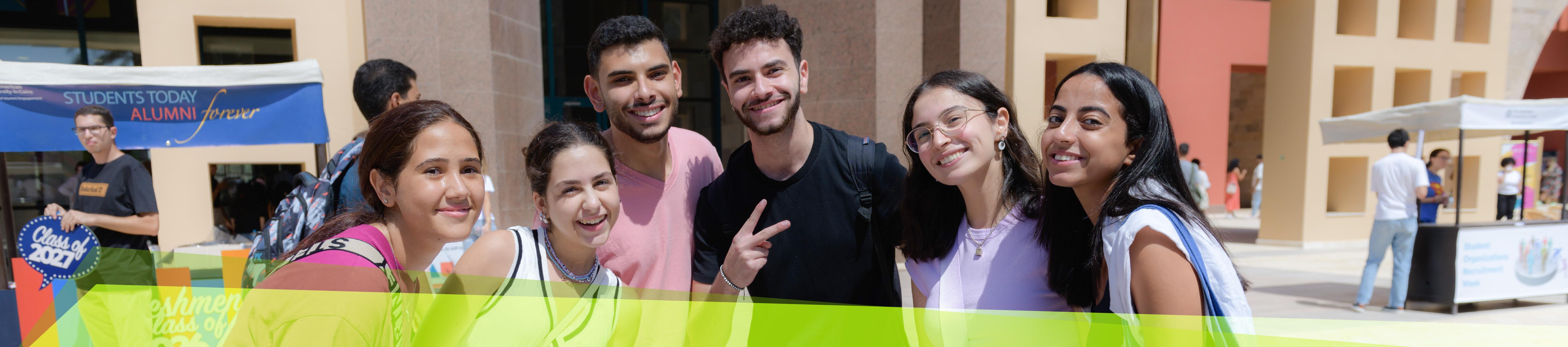 A group of boys and girls on auc campus plaza smiling