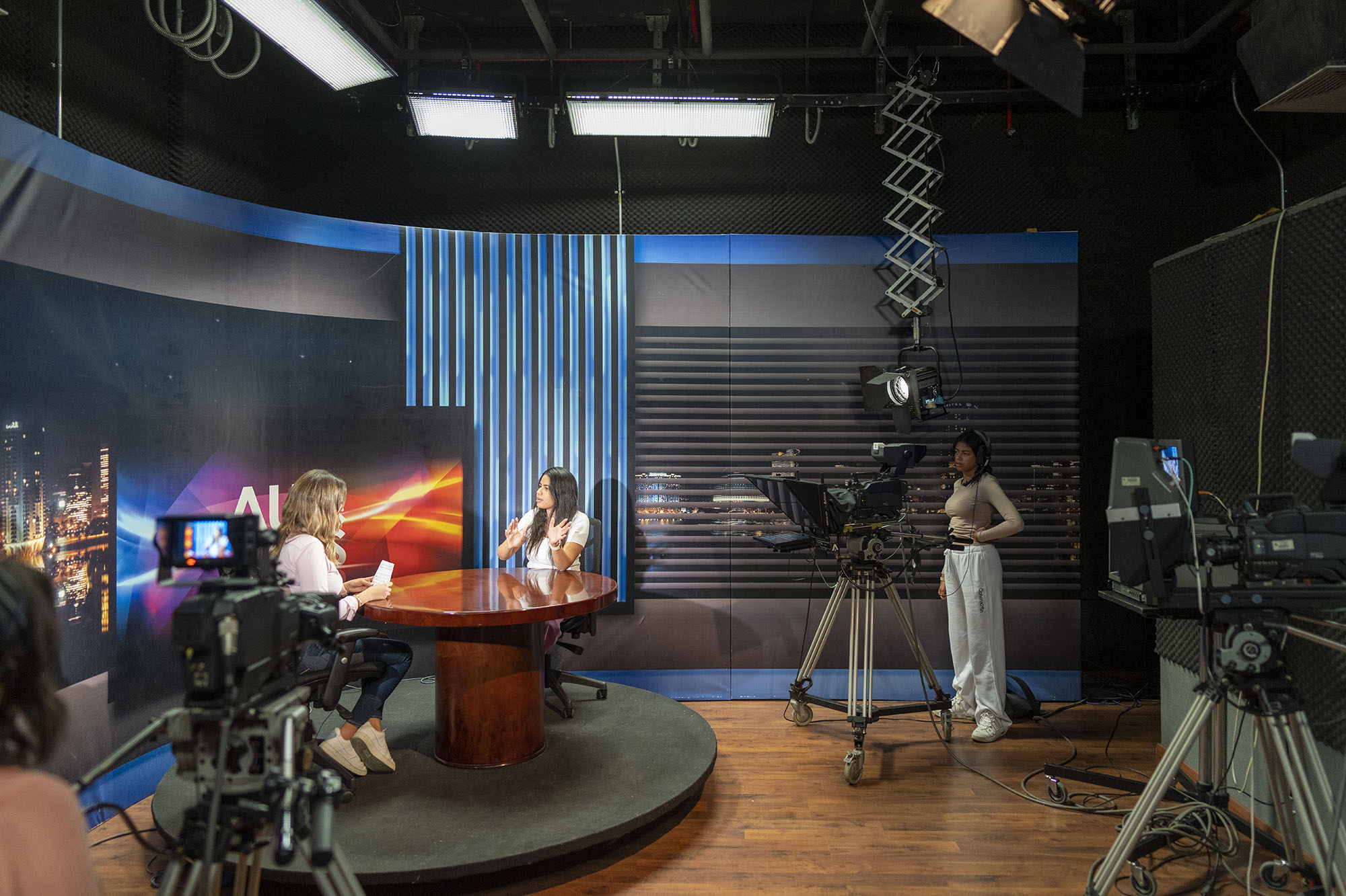 TV and journalism program image of a TV studio and students working in front and behind the camera