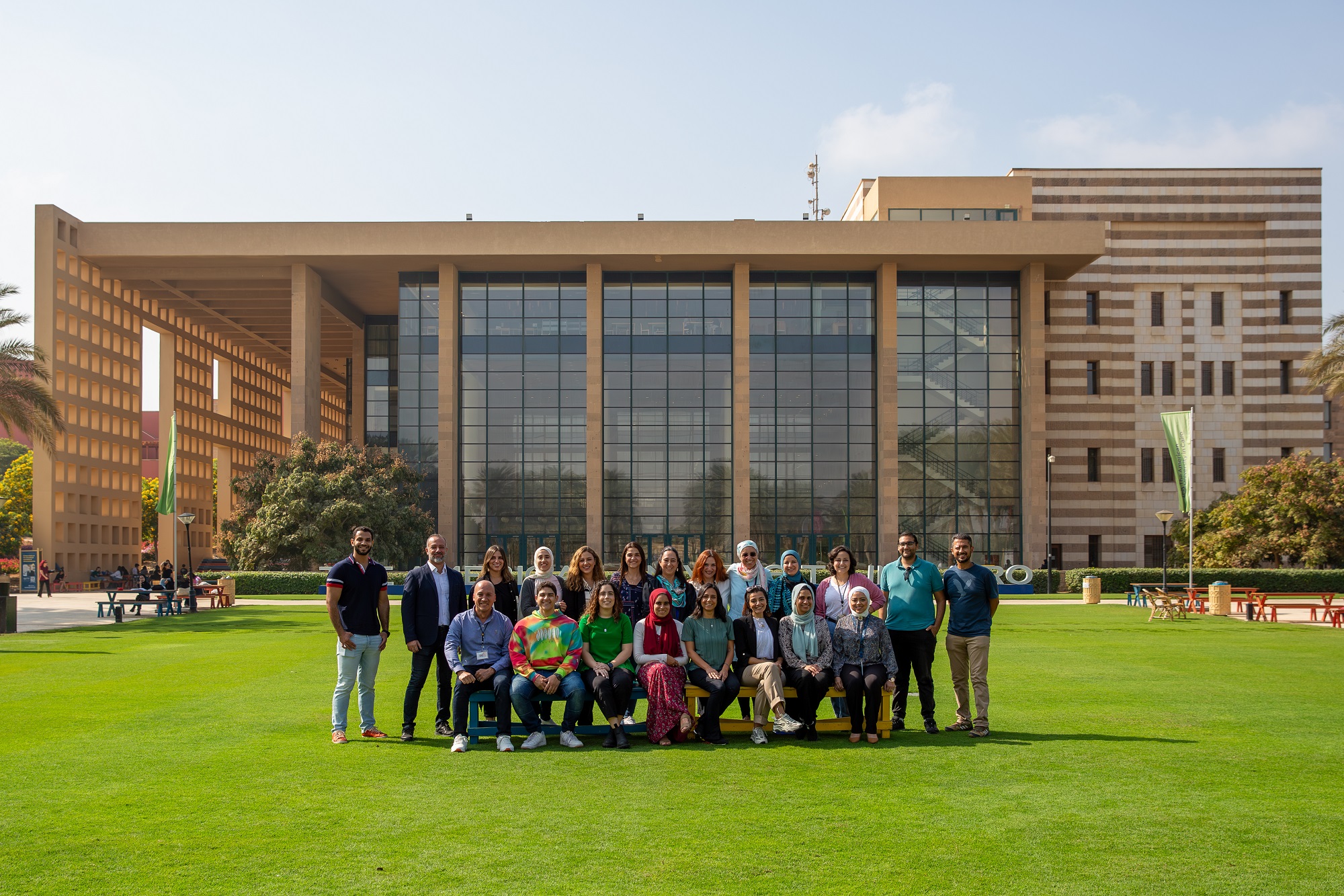 A group of men and women taking a group photo in an outdoor setting