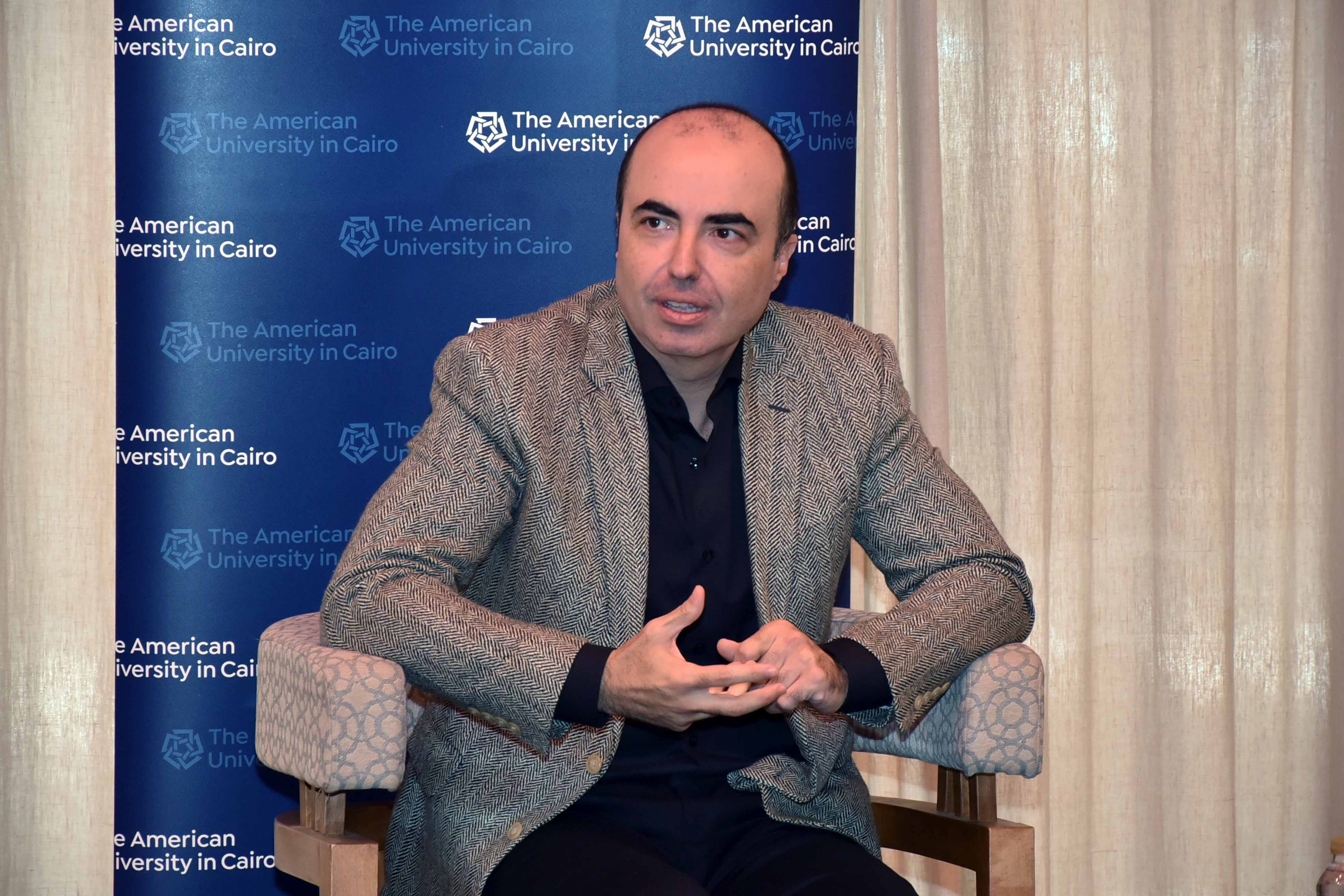 Mohamed Salama sitting on a chair talking to media panelists about his research on healthy aging