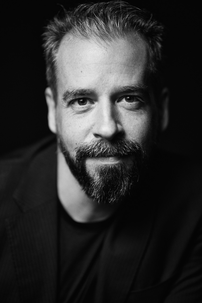 White and black head shot of a man smiling