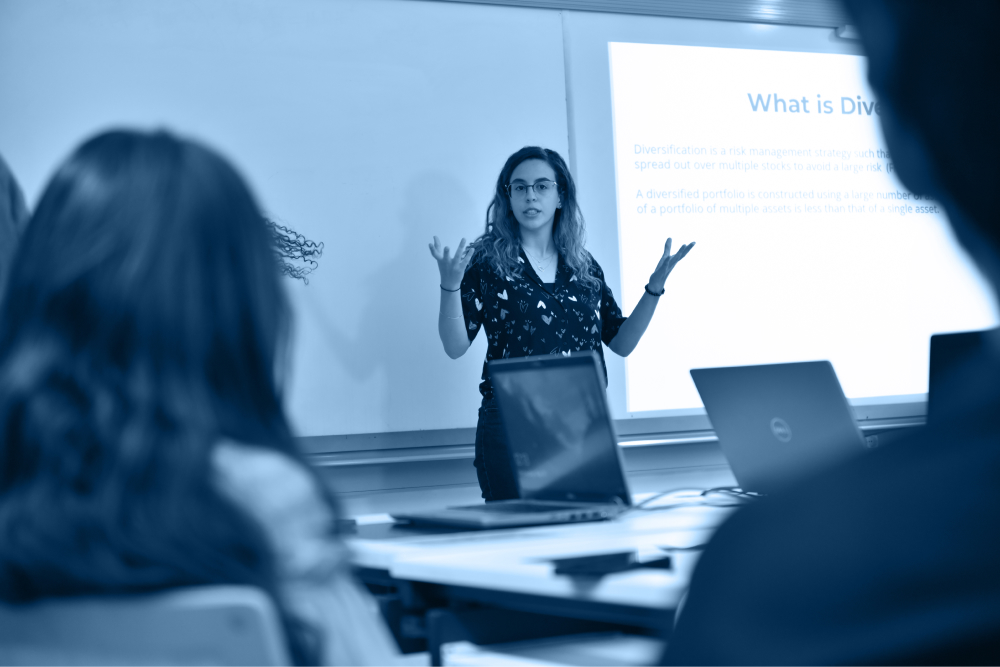 Public policy diploma monotone image of student explaining in front of classmates 