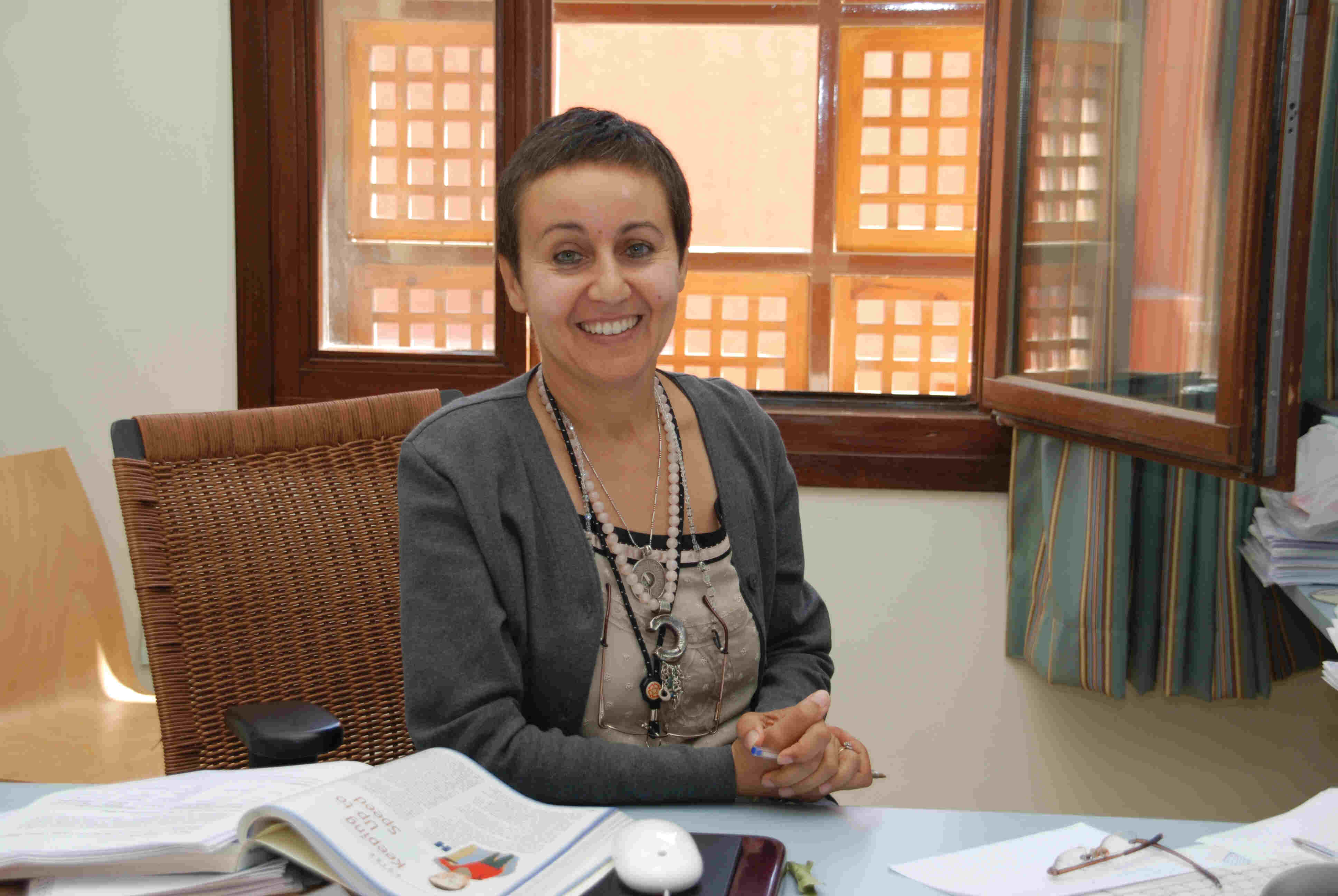 Lady sitting on a desk in an office