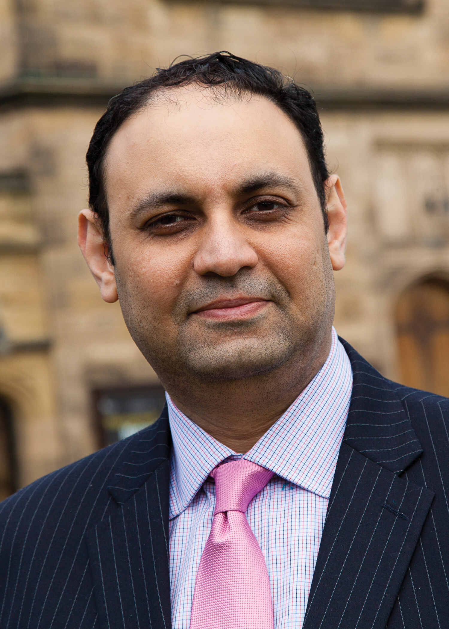 Headshot of a man wearing a suit and tie