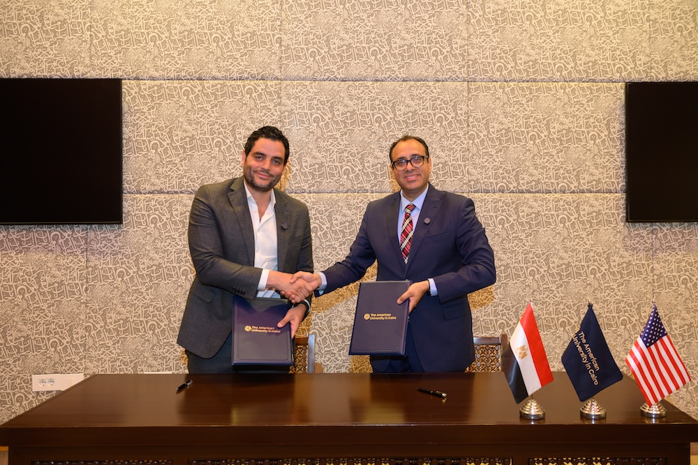 Two men shaking hands after signing agreement