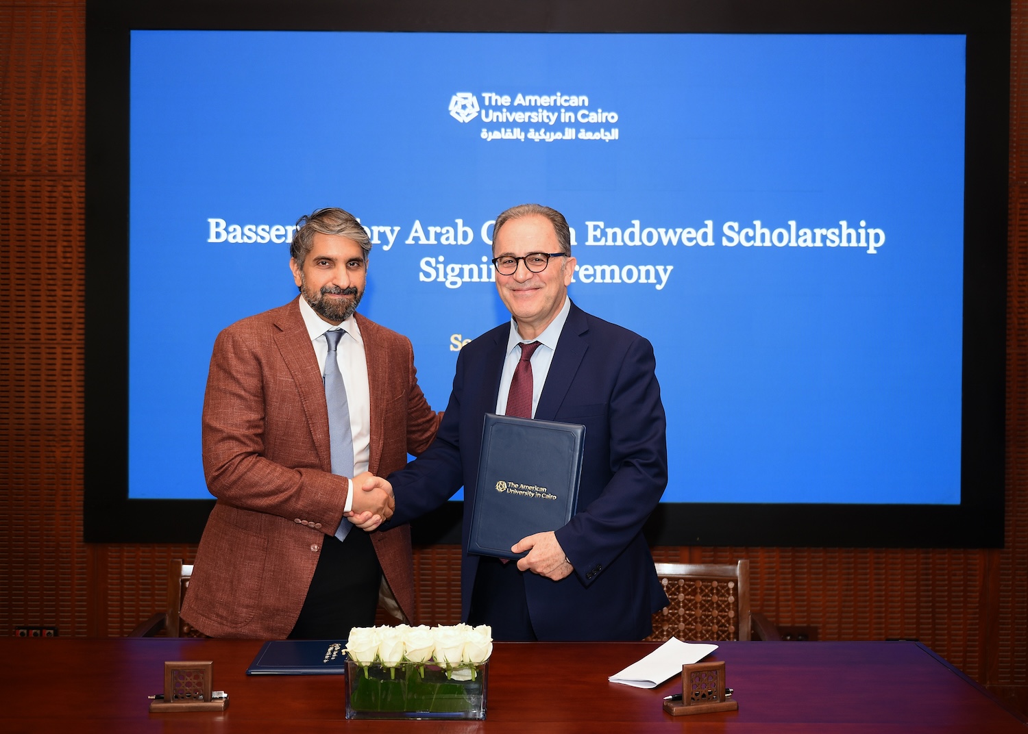 Two men shaking hands after signing agreement