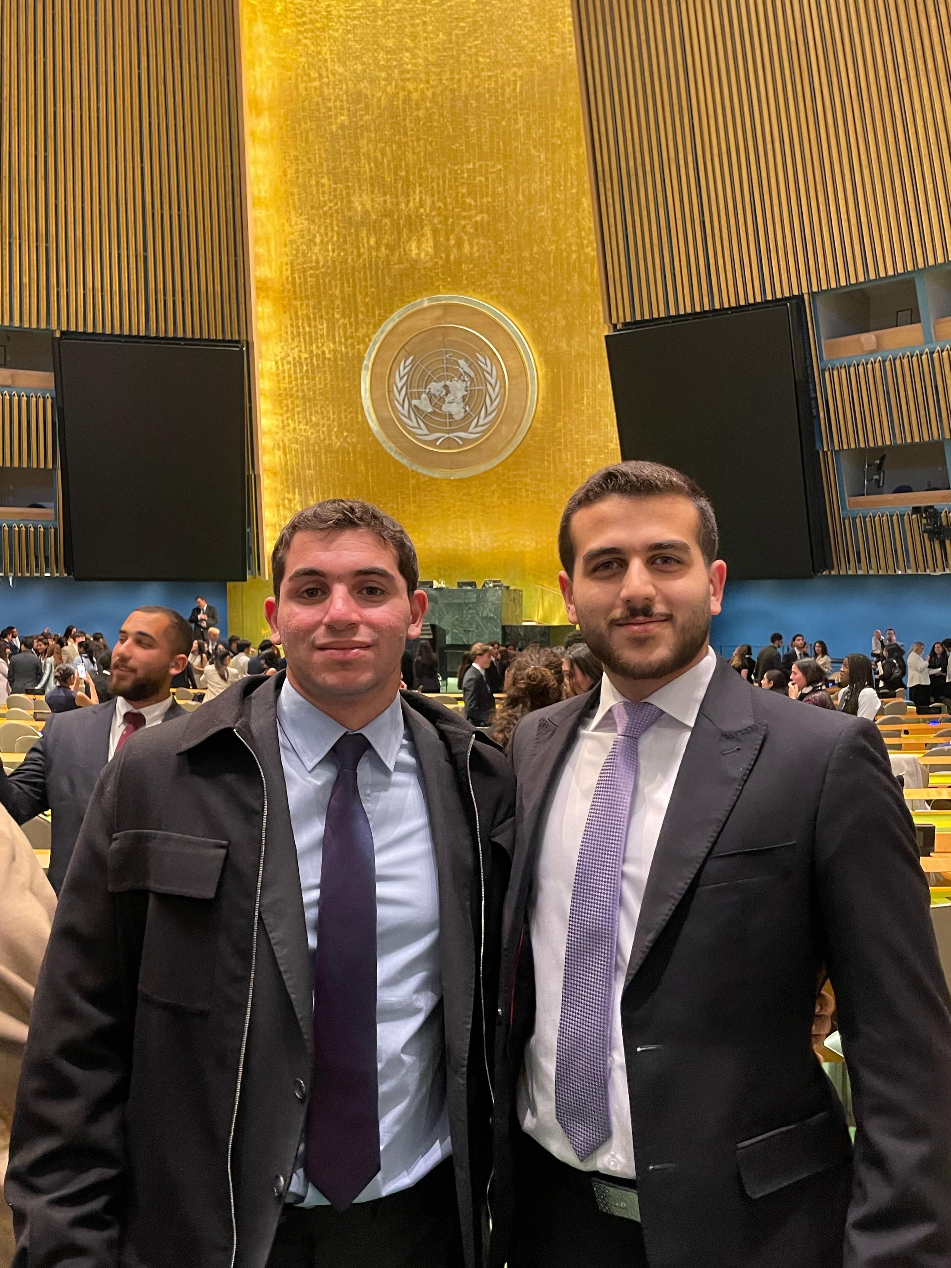 Hussein Sharif and Yousef Taha stand together in a large assembly hall