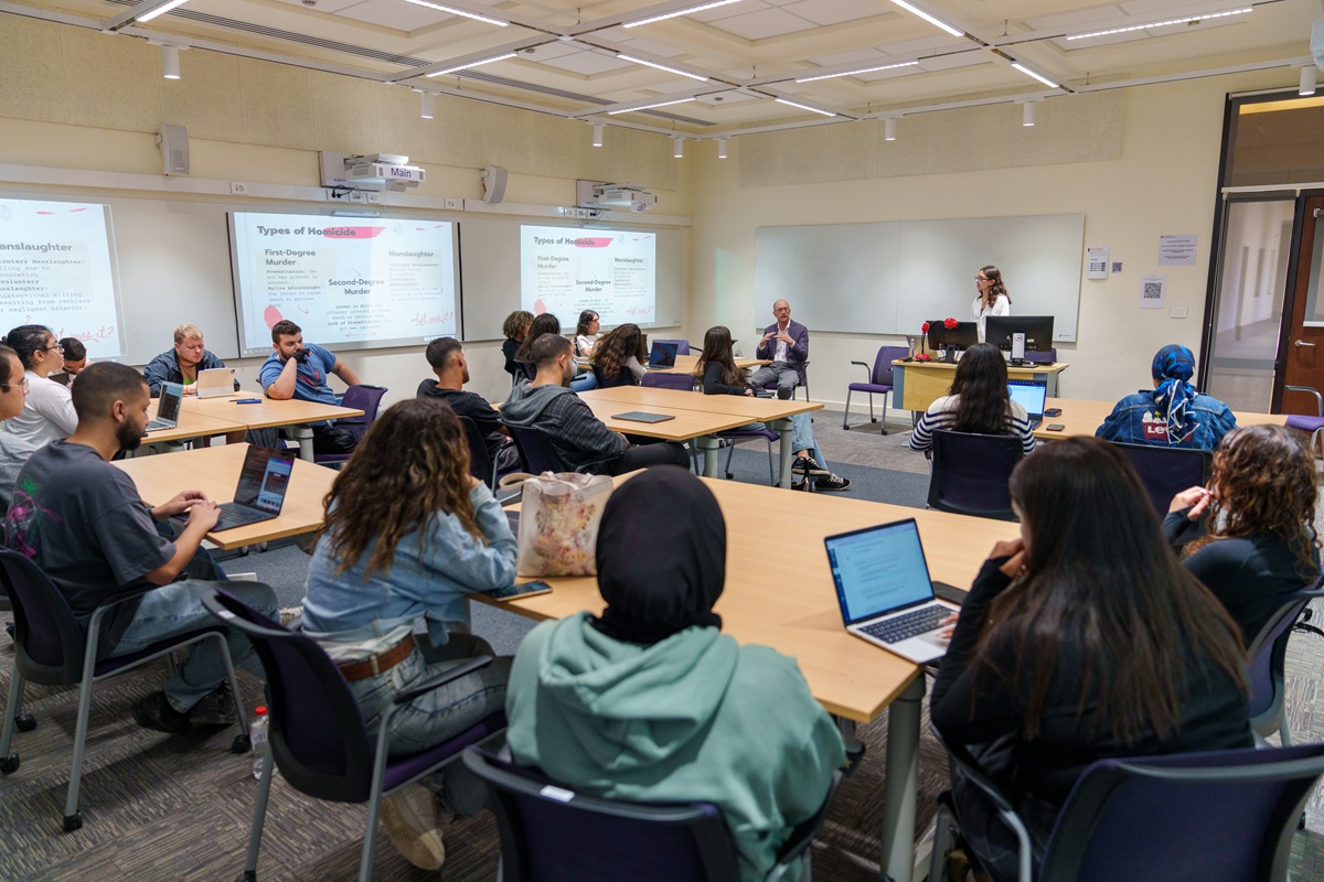 Students sitting in class and the instructor is standing in the front