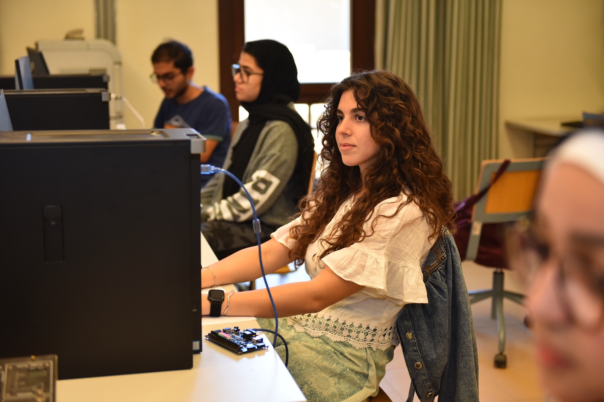 Students working at computers in a campus computer lab during a class session.