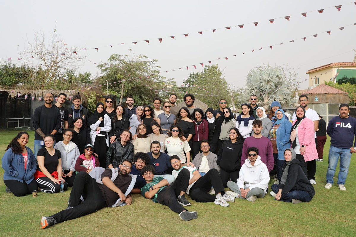 a group of girls and boys taking a group photo in the garden