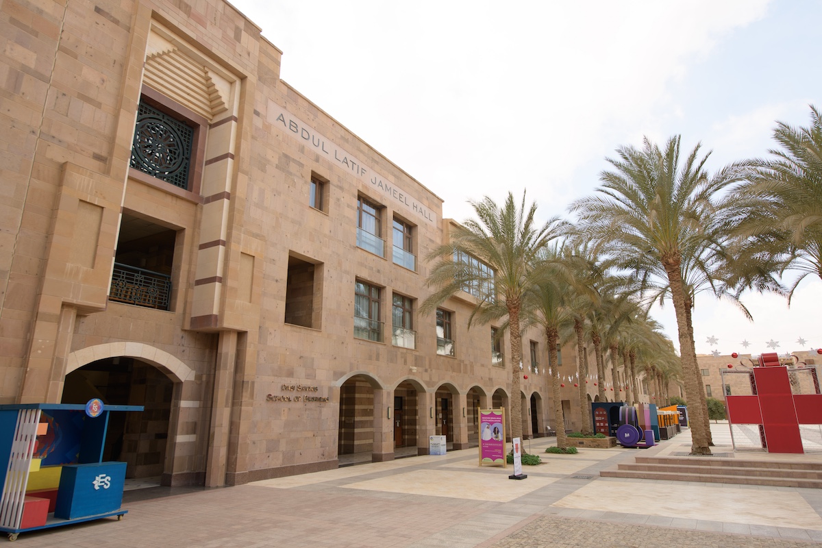 Abdul Latif Jameel campus building lined with palm trees.