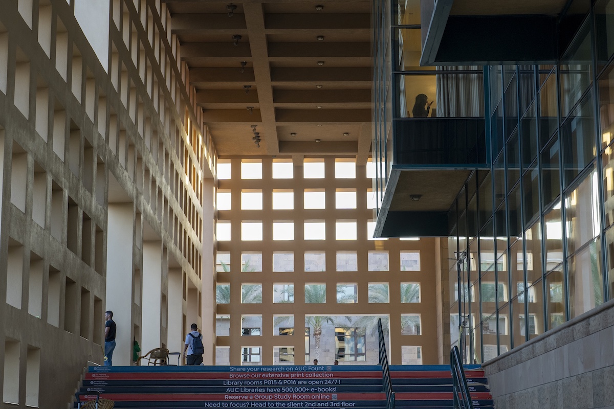Outside the AUC Library with geometric windows, open staircases, and students walking through the space.