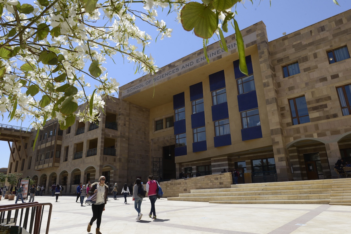 Students walk outside the School of Sciences and Engineering building on AUC&rsquo;s campus.