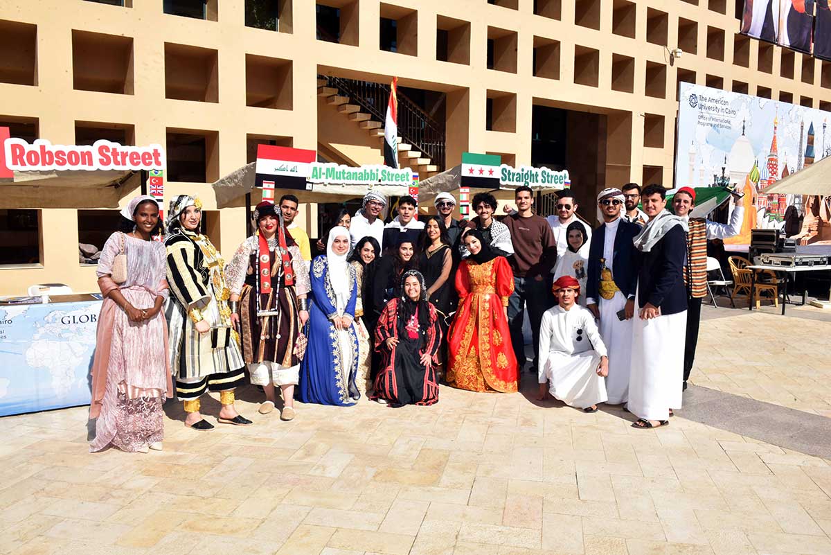 A group of students in various cultural dresses pose for a photo