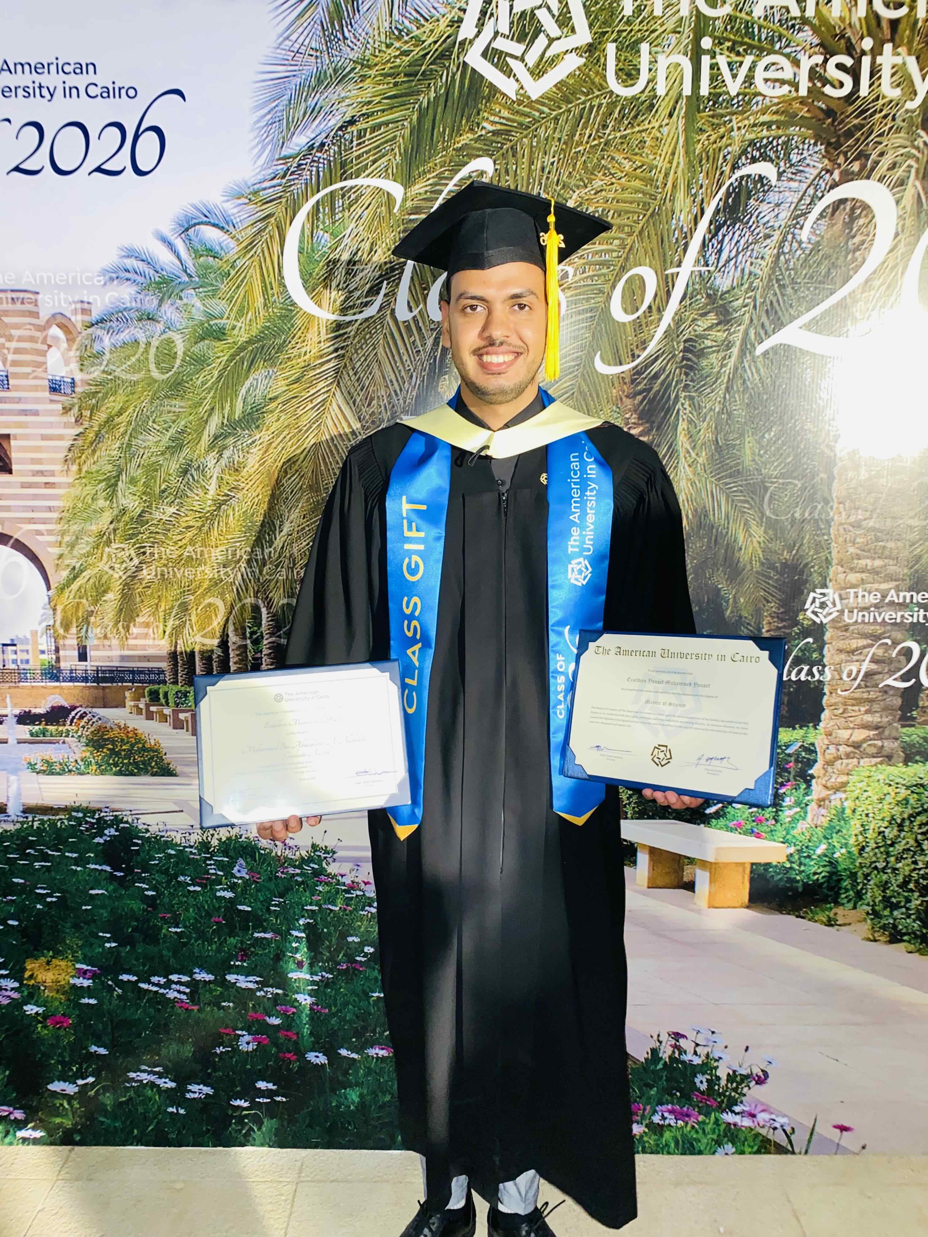 Graduate student EzzEldien Yousef holding his certificate and award at the 2026 commencement