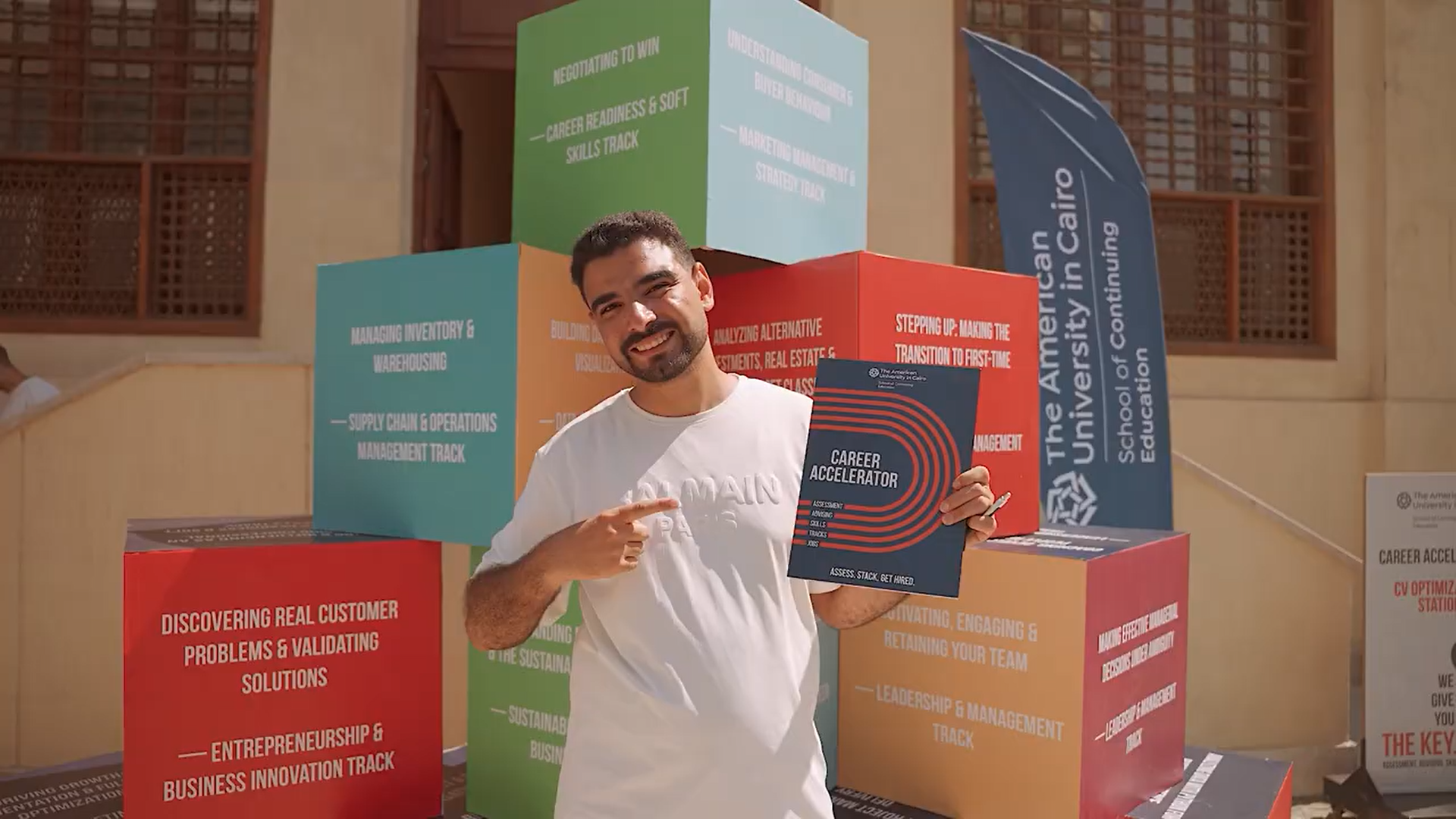 A person in front of a pyramid of cubes with text on their sides, points to a folder that says career accelerator