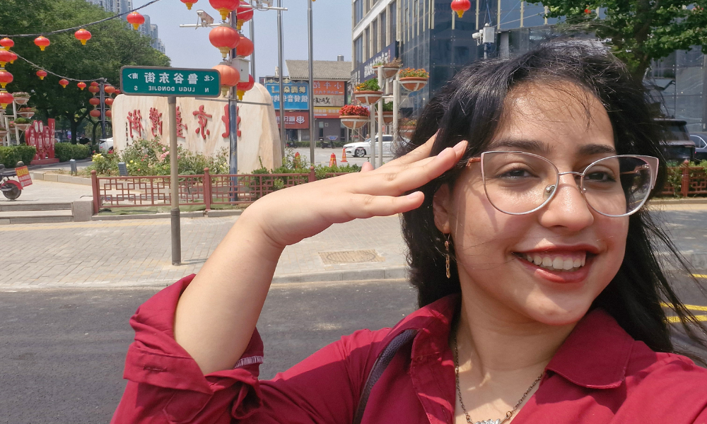 Shahd Younes takes a photo in front of a street