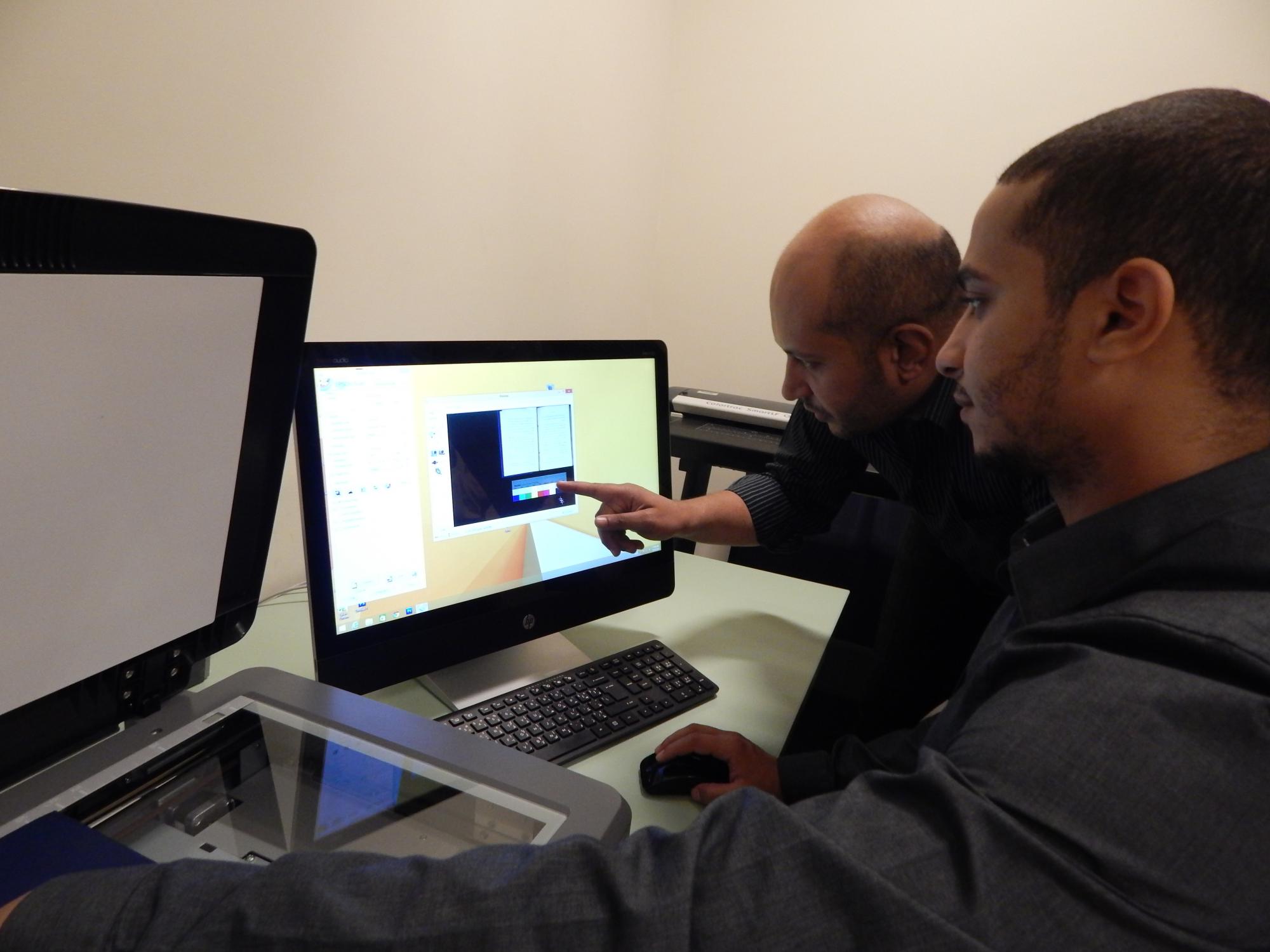 Mohamed Abdel Rehim and Mohammed Saleh scan books for AUC Library's new project with Arabic Collections Online