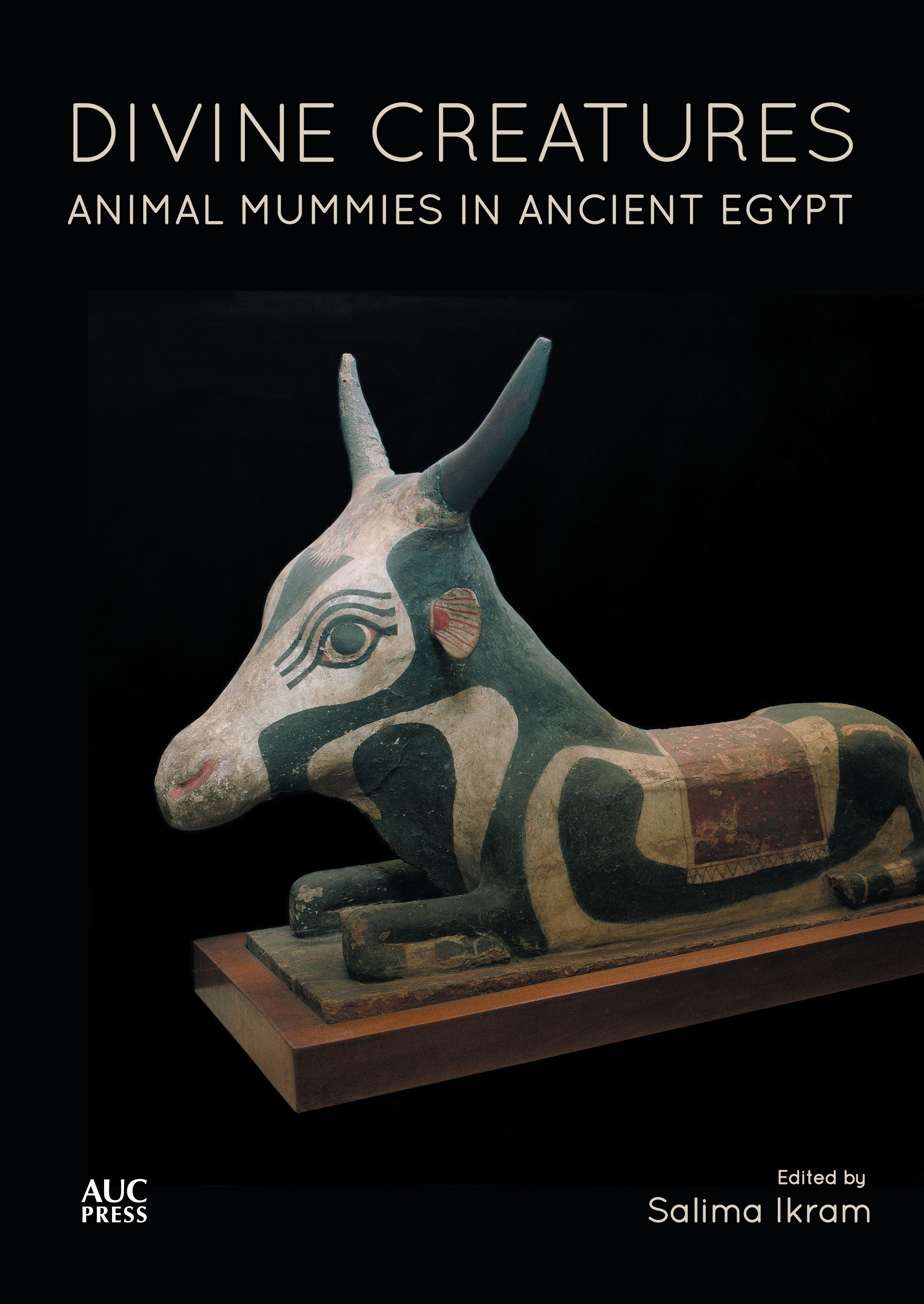 Divine Creatures: Animal Mummies in Ancient Egypt book cover featuring an ancient Egyptian sculpture of a cow kneeling at rest