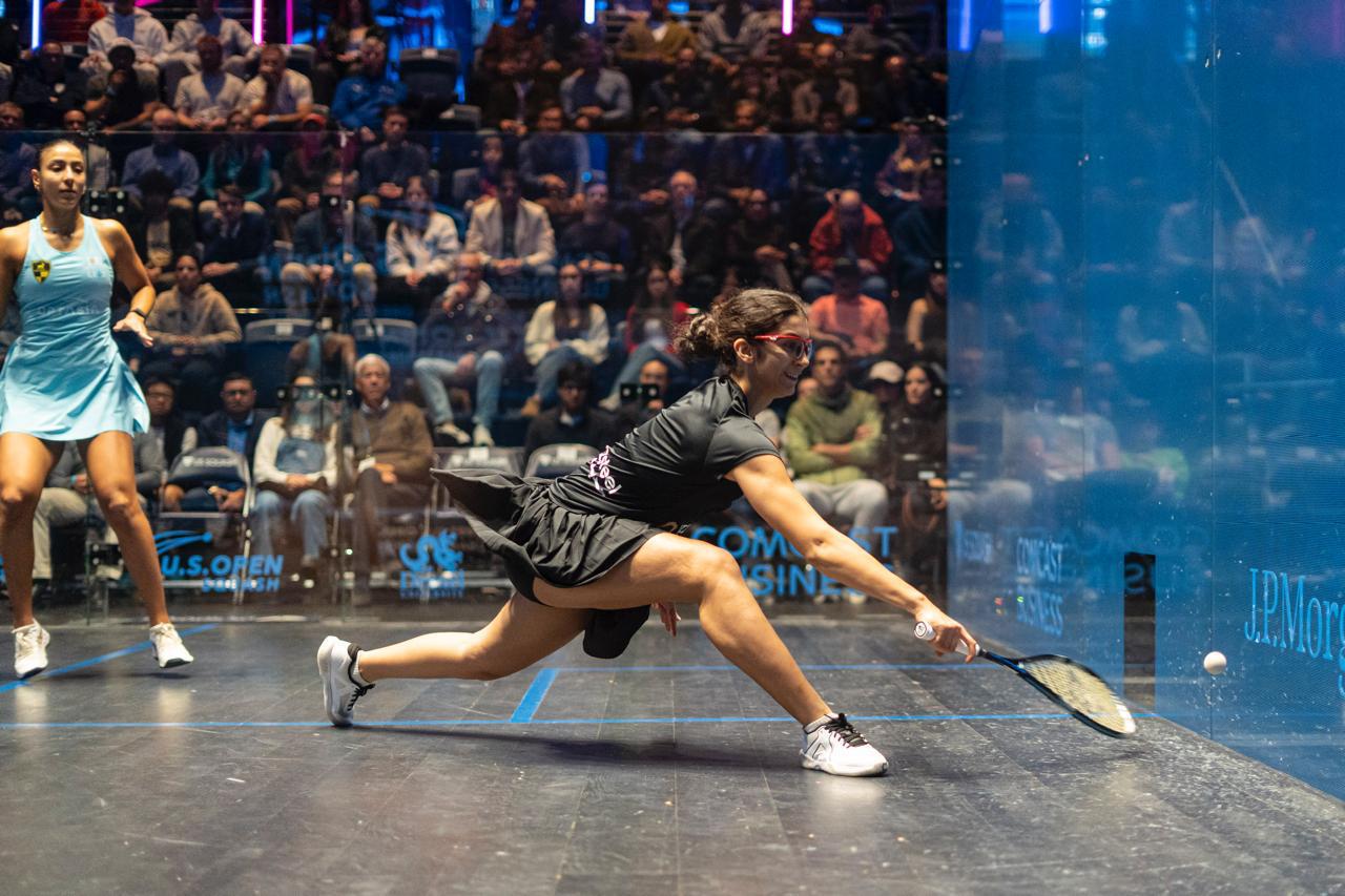 Amina Orfi reaches to stop a ball from hitting the ground on the squash court