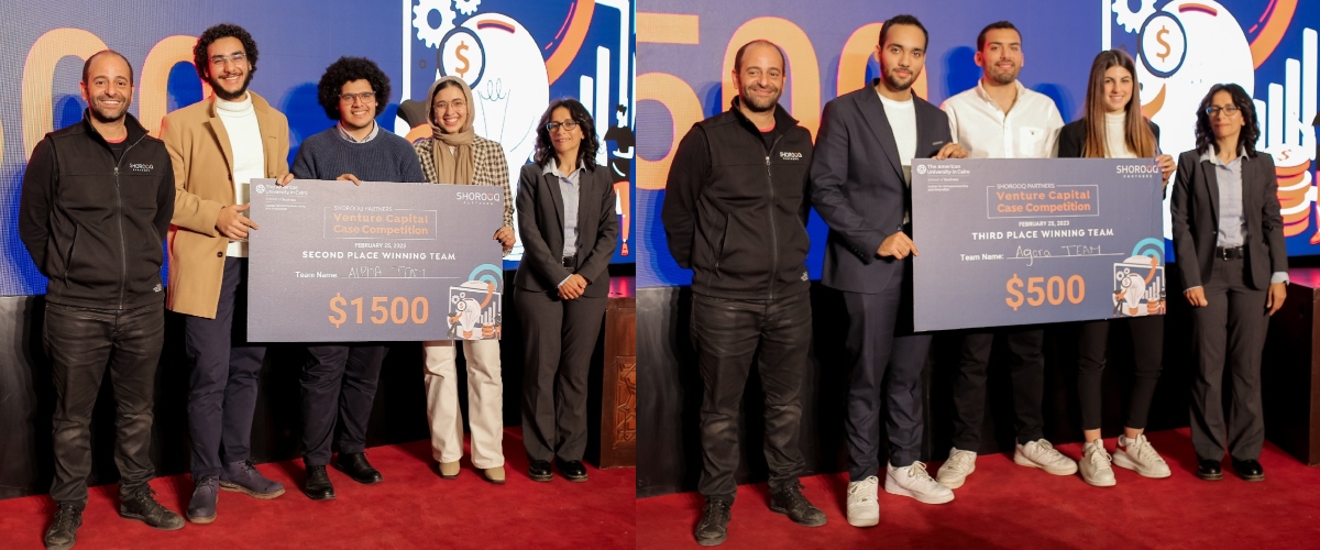 Second and third-place winners stand on the stage holding giant checks for $1500 and $500