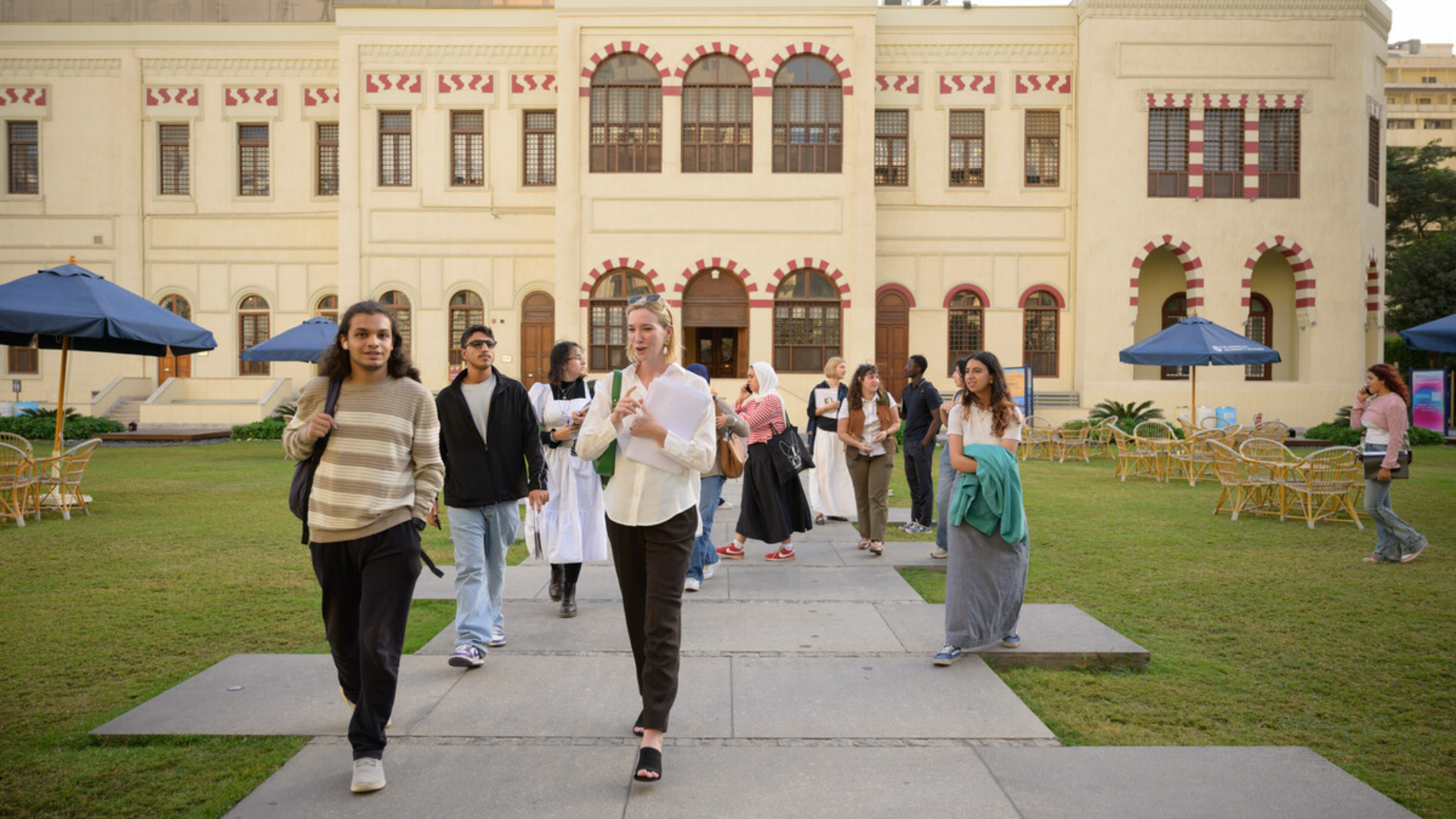 A group of students walk outside a large palace.