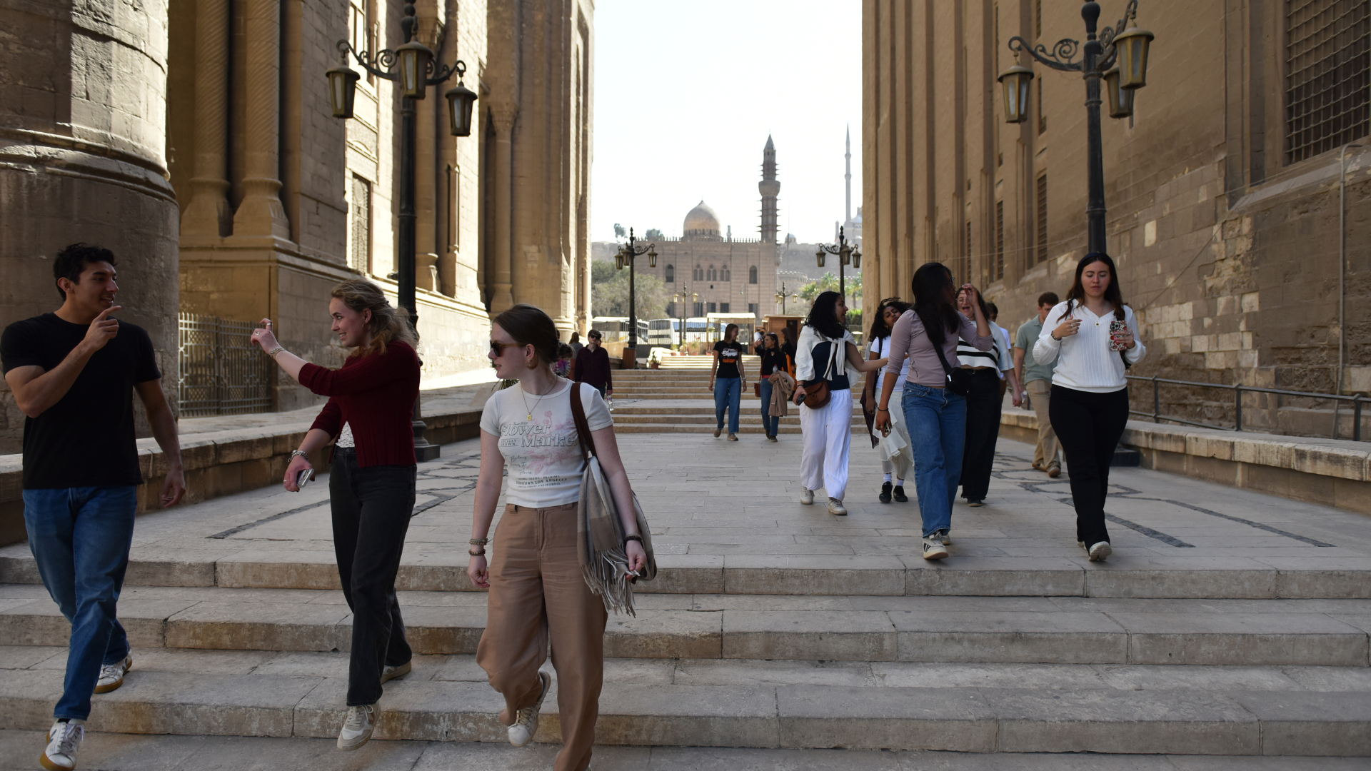 A group of students talk and walk through a wide alley