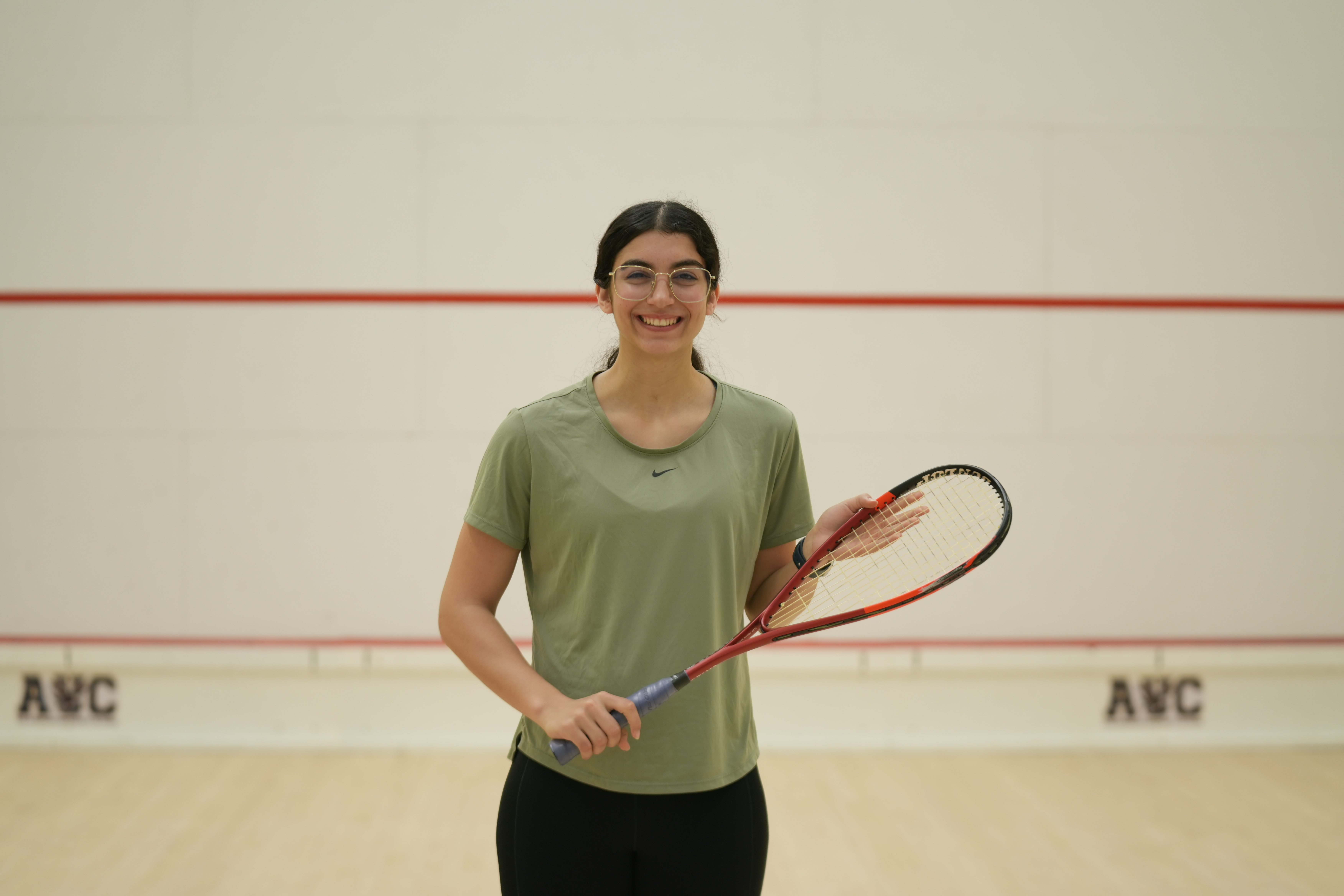 Amina Orfi stands in a squash court