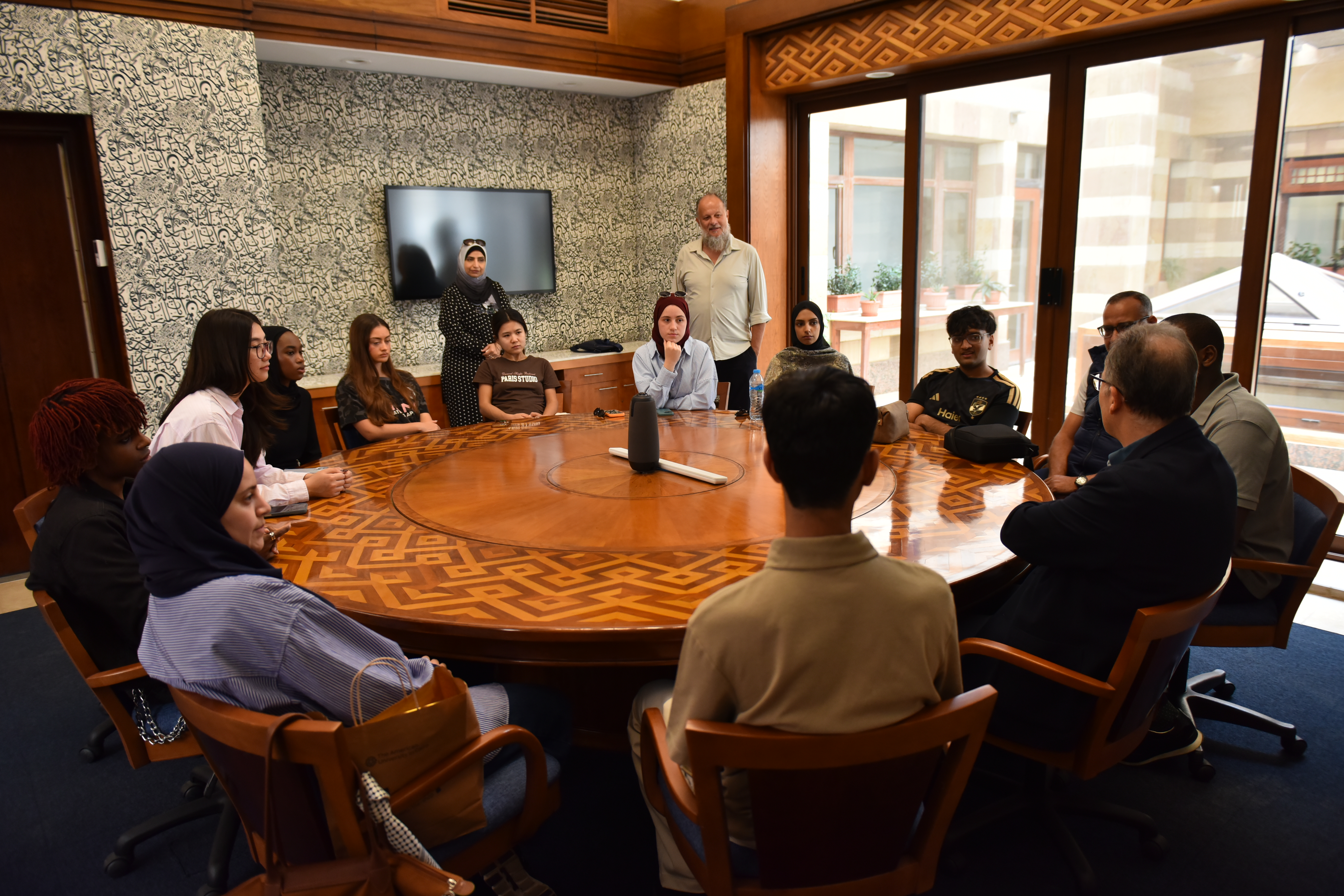 GU-Q students sitting at a round table meeting with Dallal