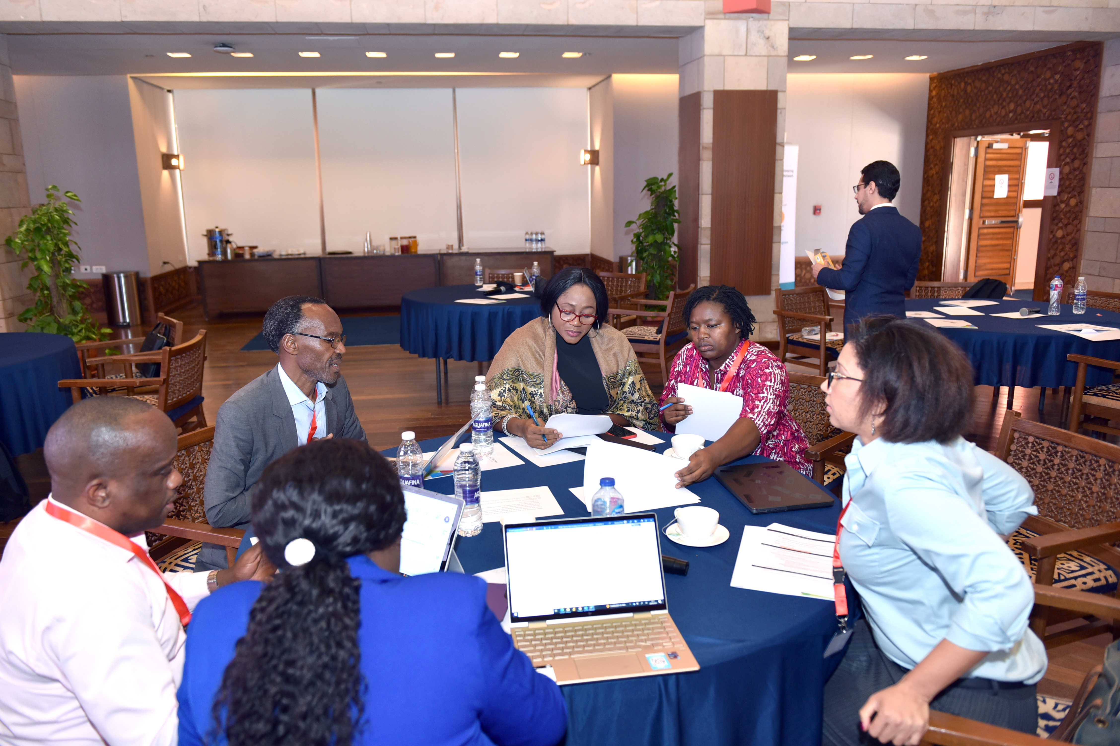 A group of workshop attendees collaborate at a table at the conference.
