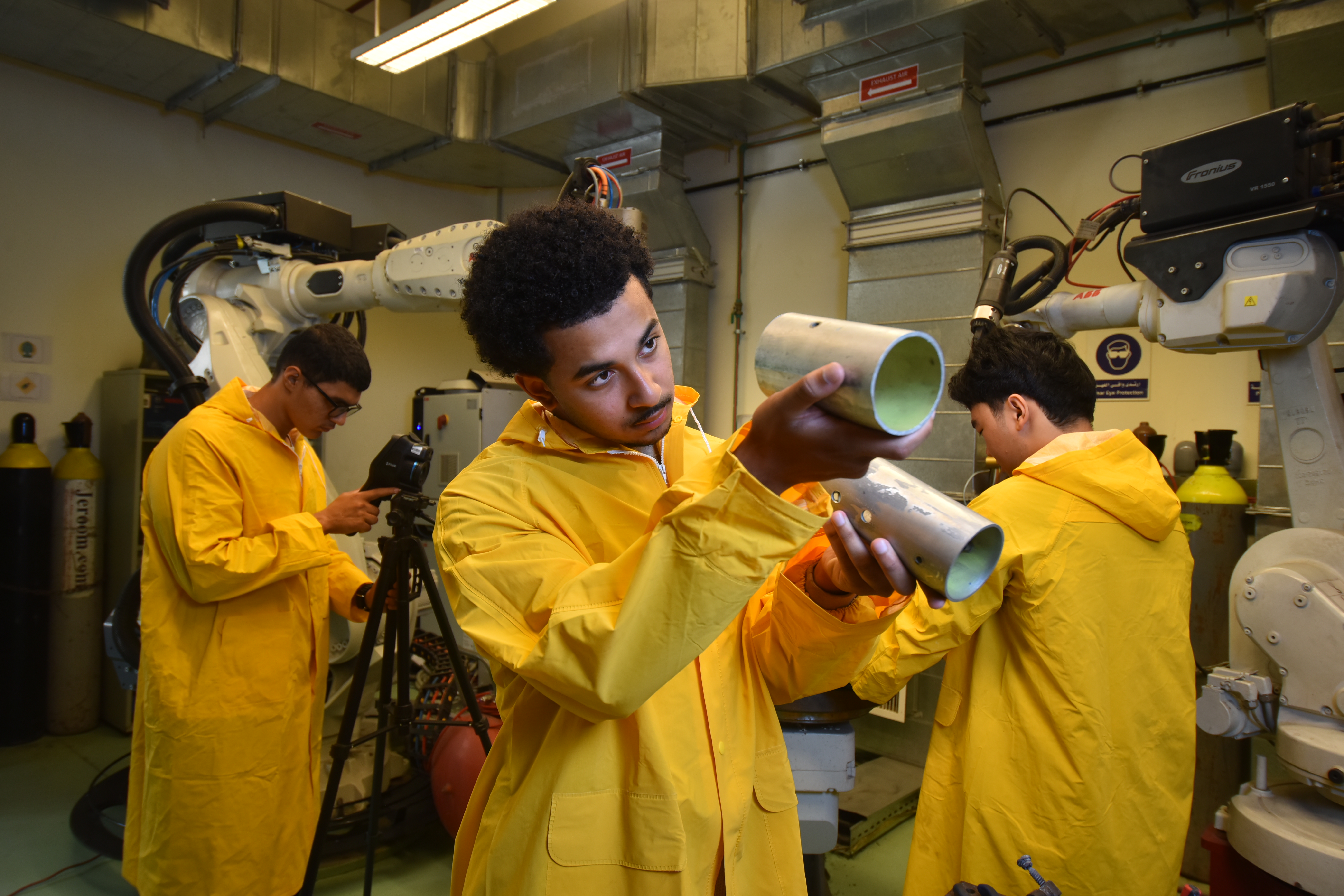 Yusef Primus inspects two metal tubes in both of his hands