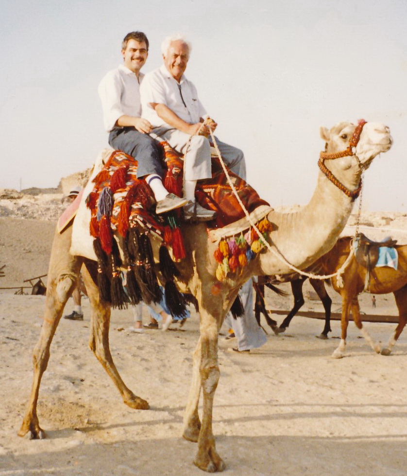 a man and his father riding on a camel