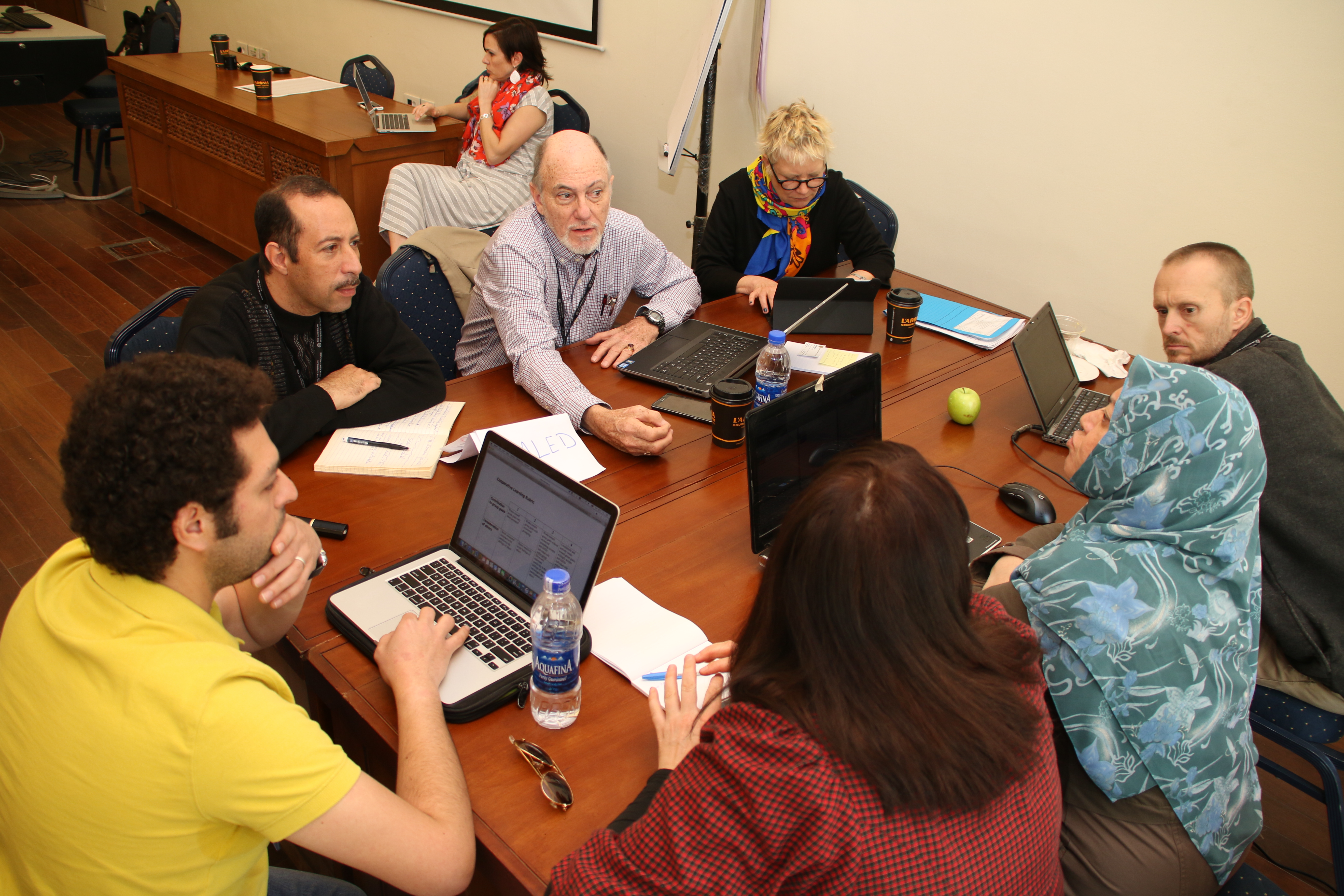 People gathered around a table working on laptops