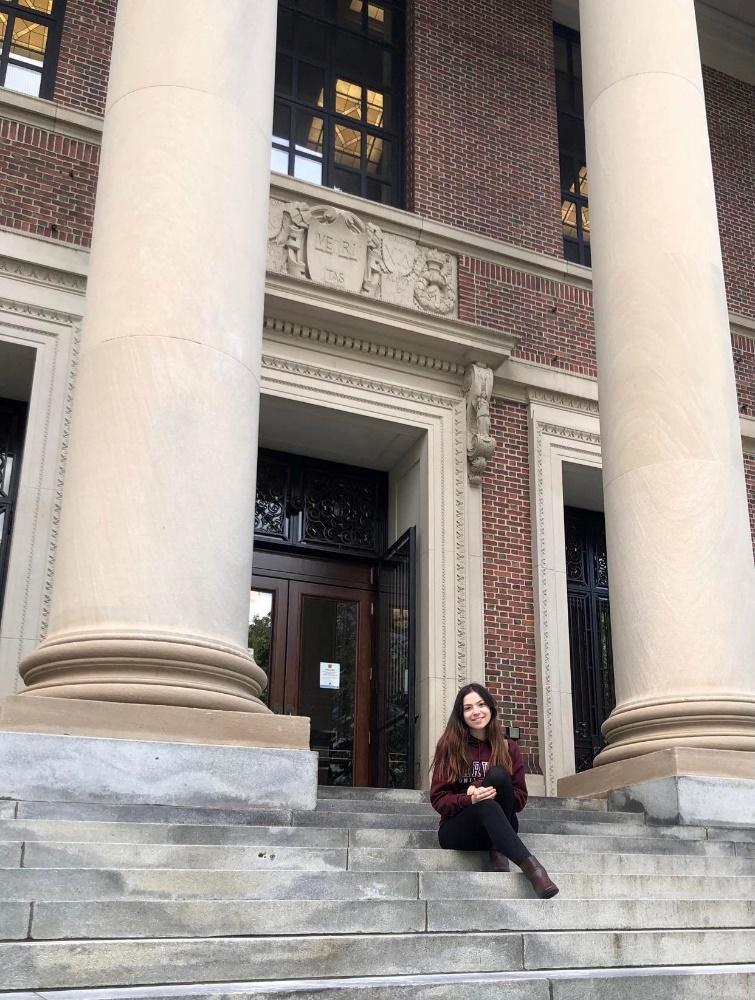 Nour-Lyna Boulgamh sits in front of Harvard University