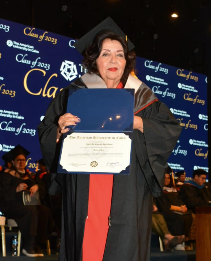 Abdel-Motaal poses with her degree at commencement, wearing a cap and gown