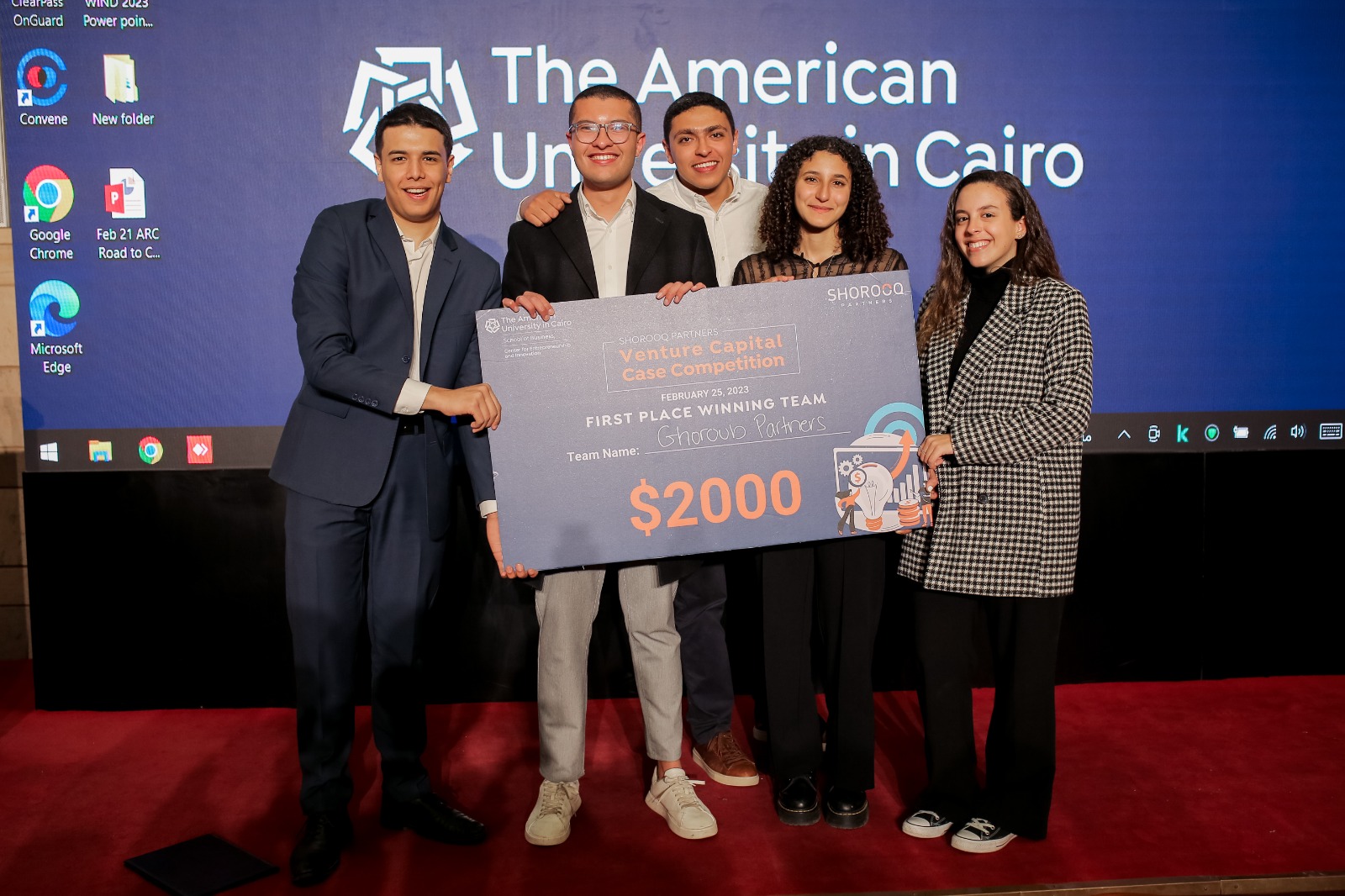 students standing on stage with a giant check for $2000