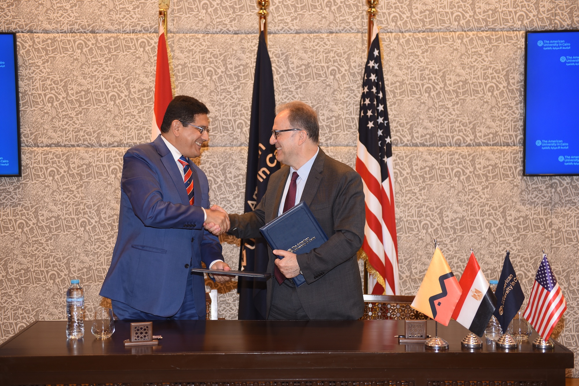 UC President Ahmad Dallal and Attijariwafa bank Egypt Chief Executive Officer and Managing Director Mouawia Essekelli shake hands after signing an agreement