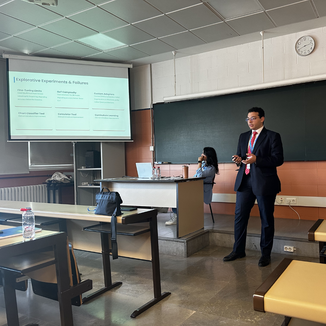 One of the students standing in a student presenting their research with a slide show to the side