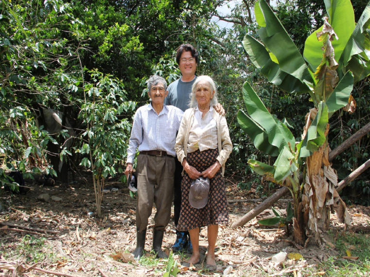 Man stands with two centenarians in Ecuador