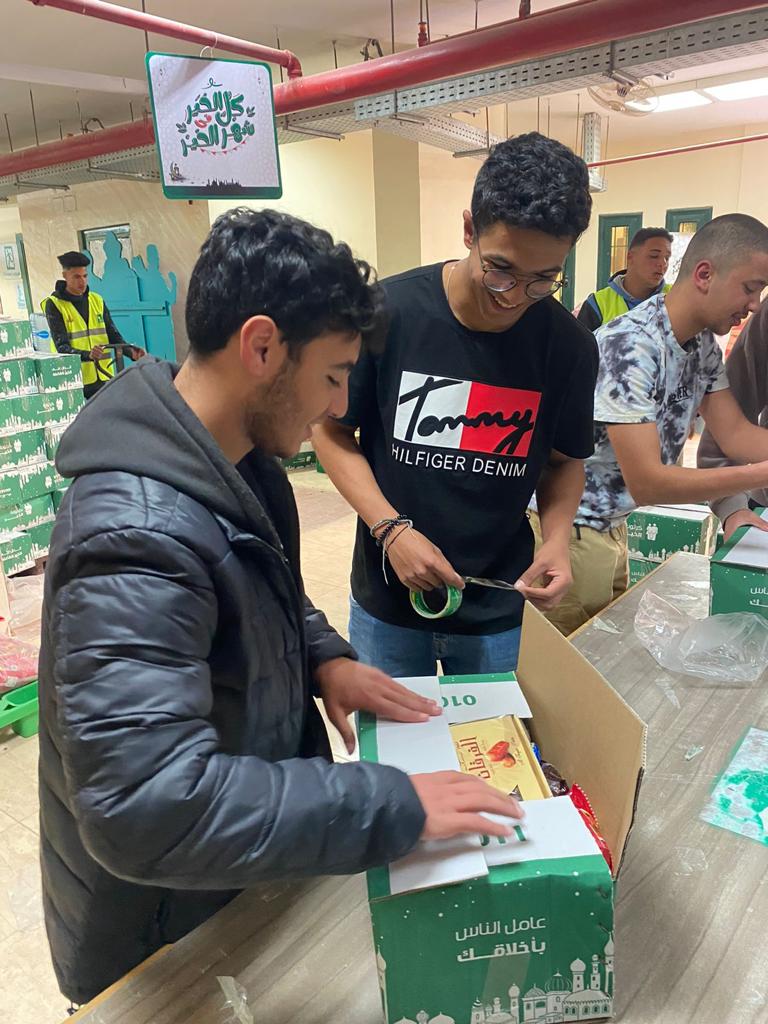A Hand in Hand member works at a local high school in assembling Ramadan food packs