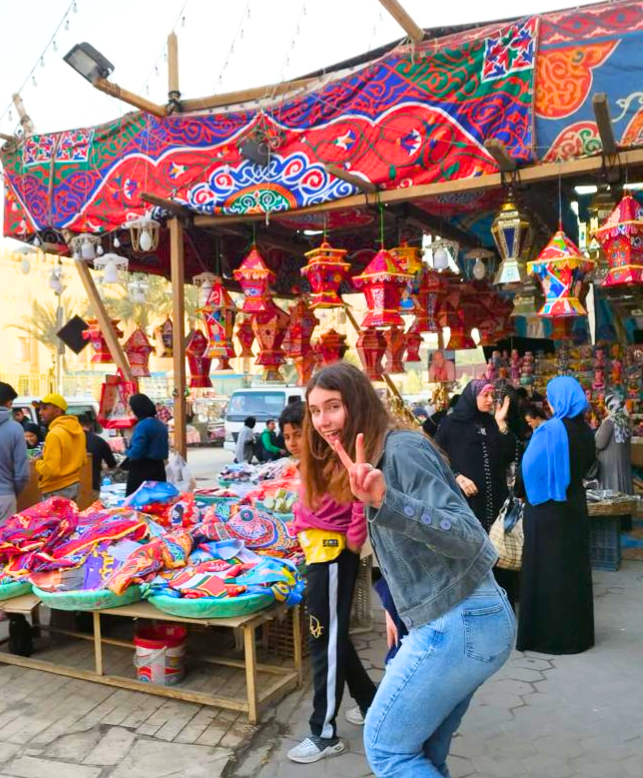 Carere smiles and poses with a peace-sign in front of a shop selling lanterns in downtown Cairo