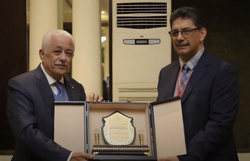 Two men standing and holding an award between them