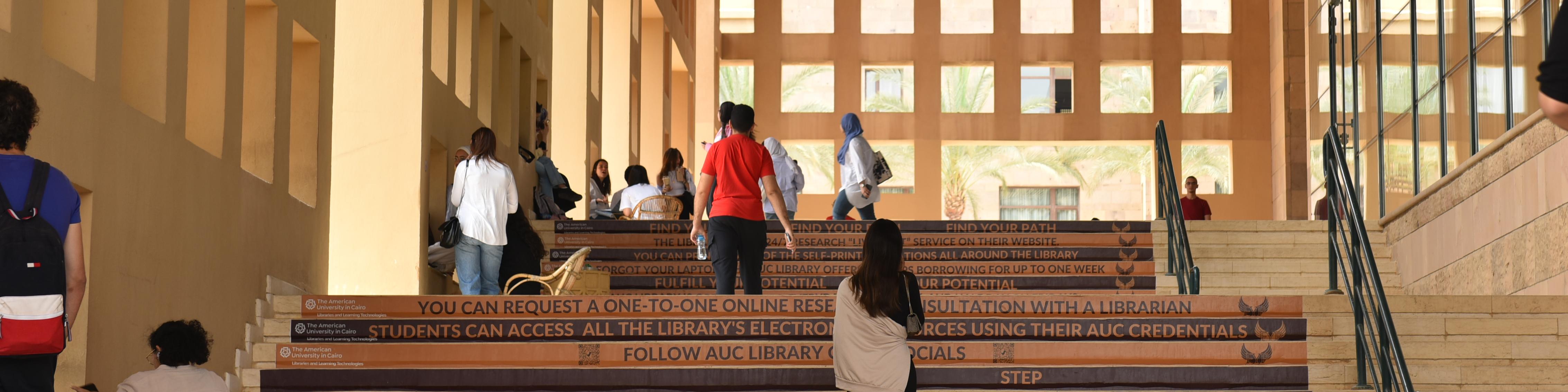 students walking by the library stairs